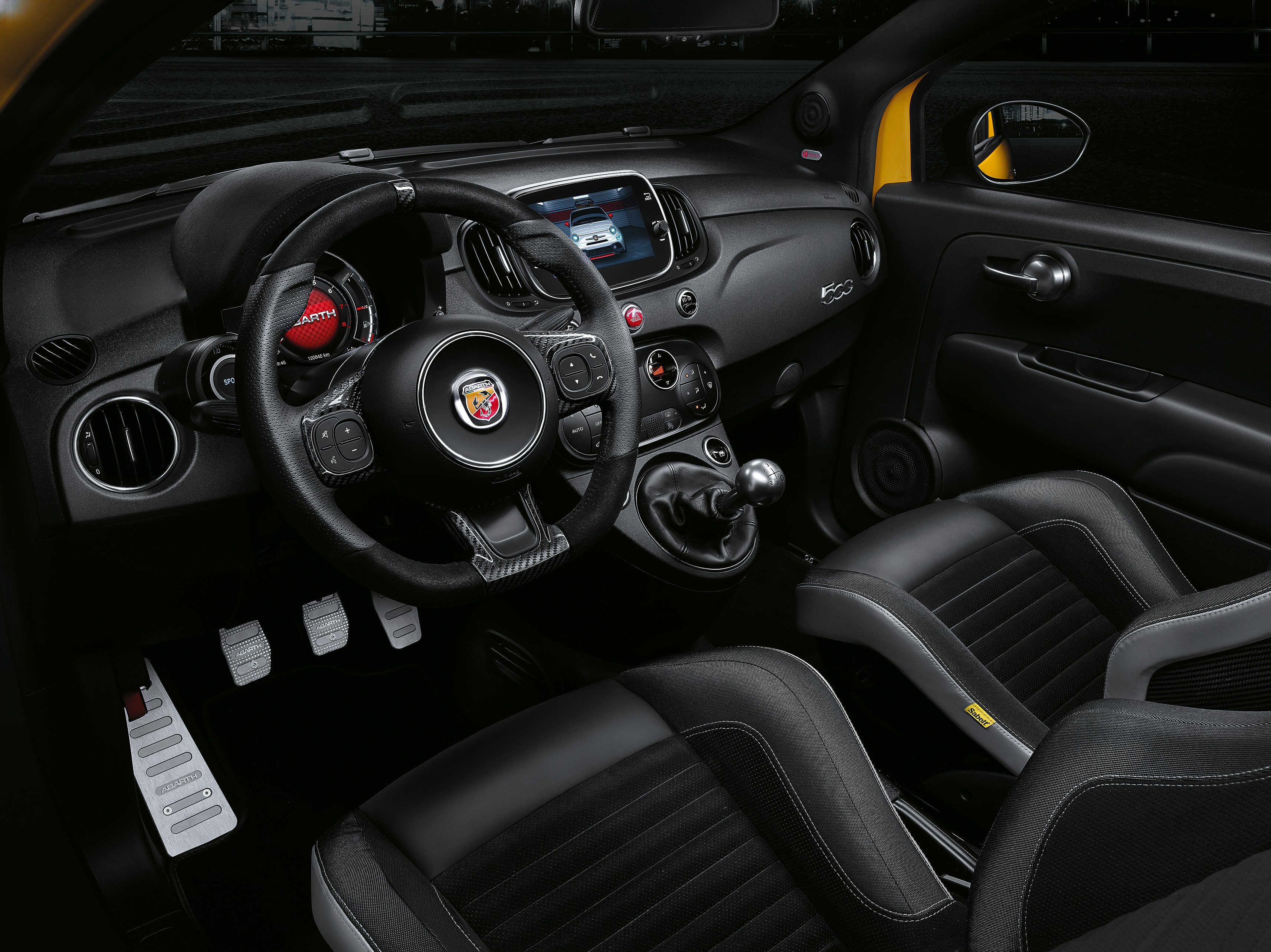 Interior del Abarth 500 con acabados en carbono y volante deportivo.