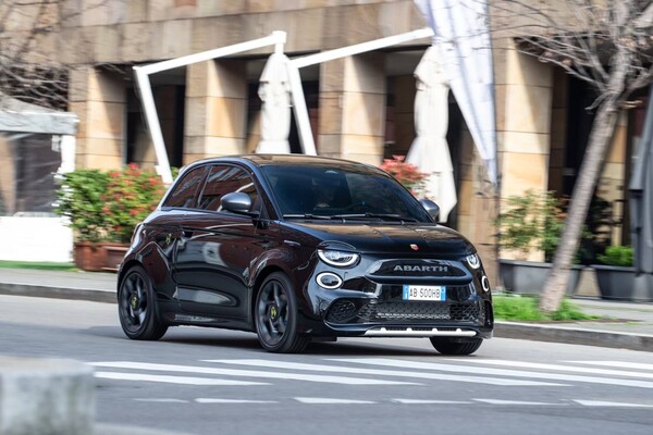 Abarth 500e con acabado en negro captado en plena aceleración por la ciudad, frontal en detalle. Abarth 500e con acabado en negro captado en plena aceleración por la ciudad, frontal en detalle.