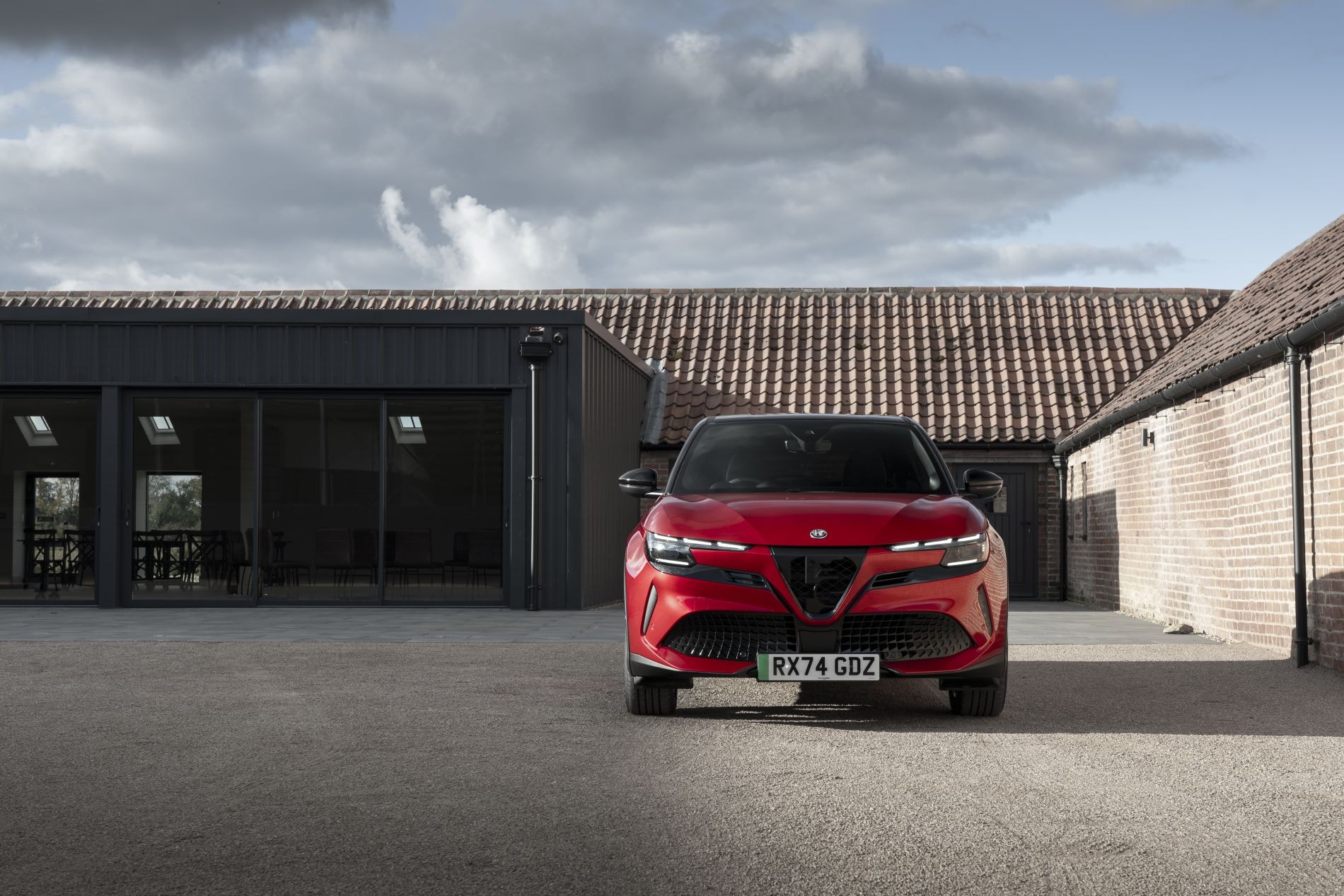 Alfa Romeo Junior eléctrico en un entorno urbano, resalta su estilo.