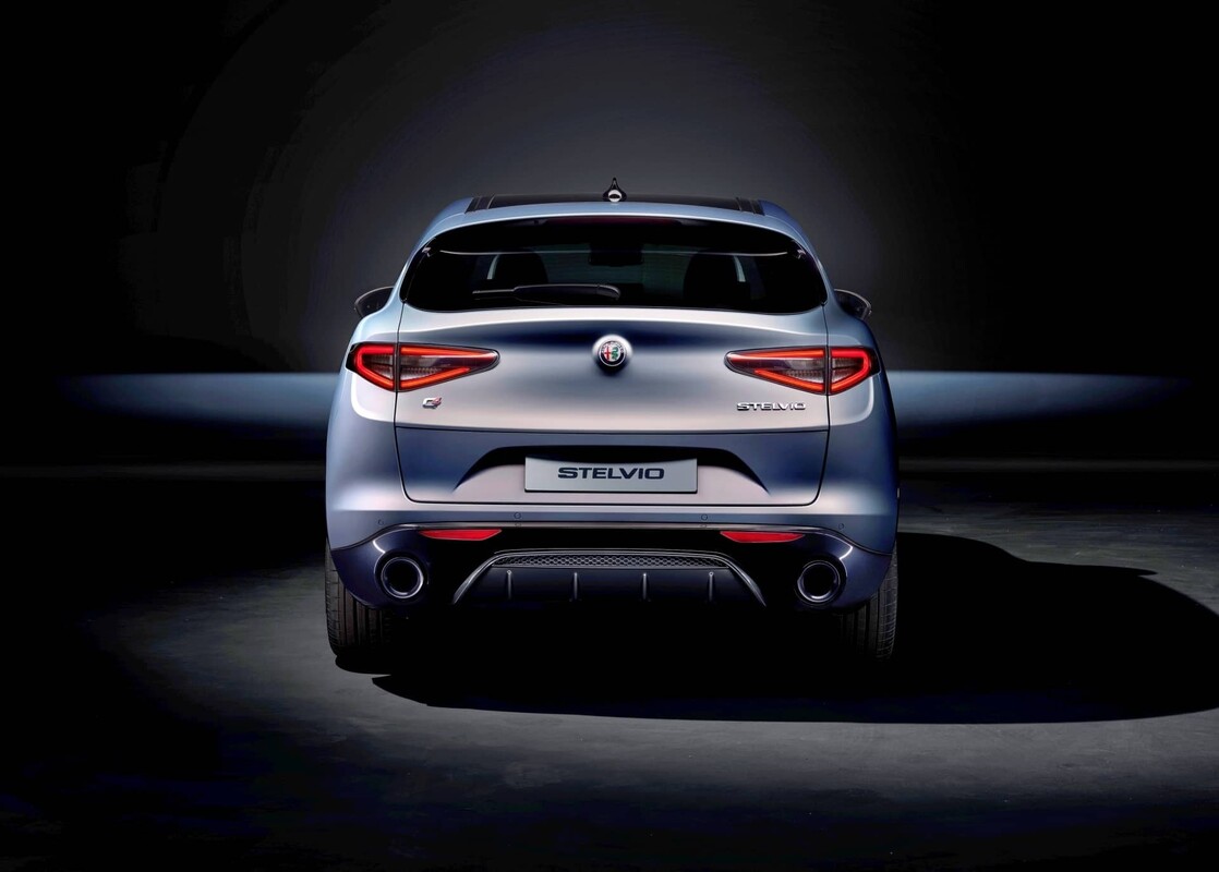 Silueta trasera del Alfa Romeo Stelvio iluminada en la penumbra Silueta trasera del Alfa Romeo Stelvio iluminada en la penumbra