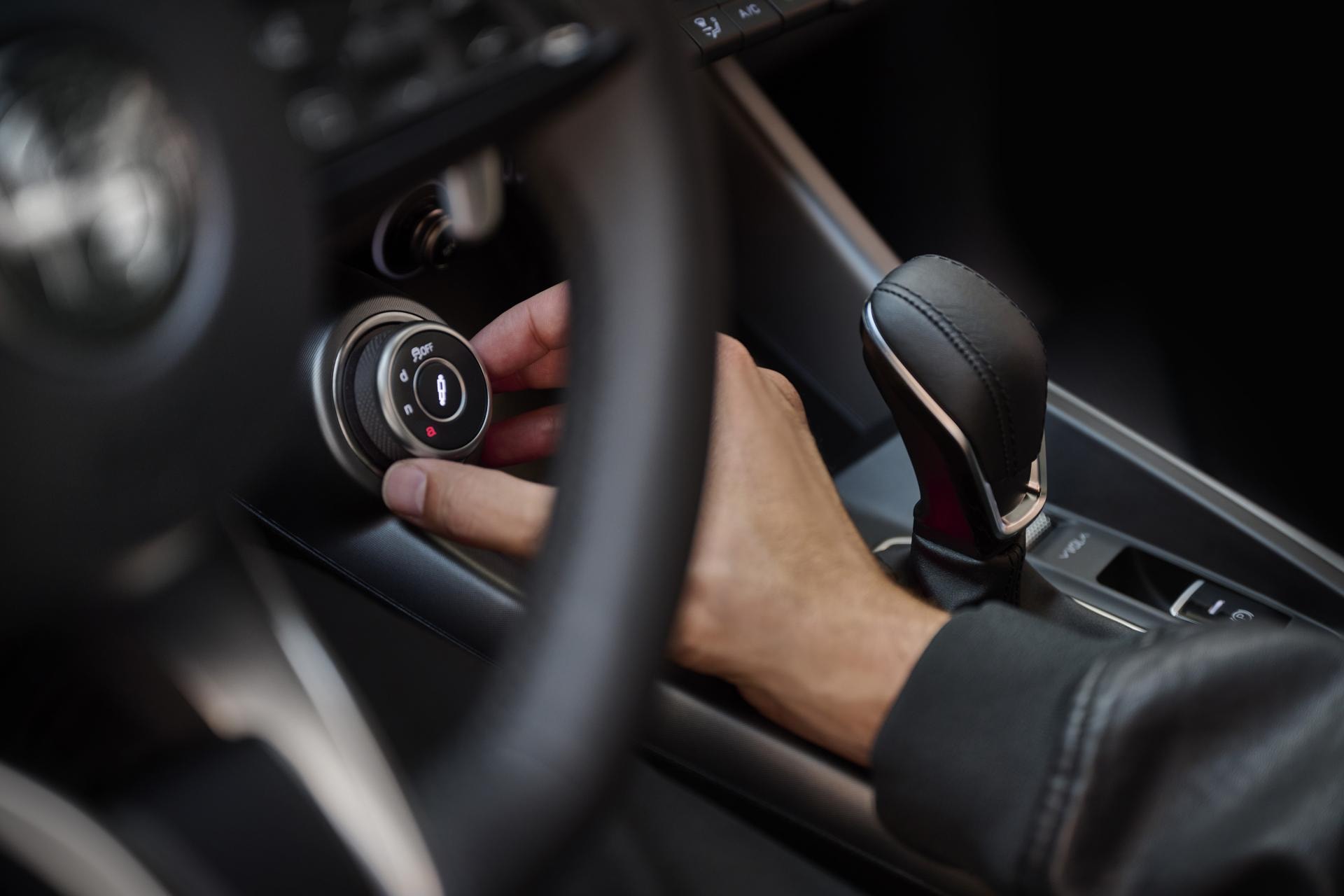 Mano accionando el botón de encendido en el Alfa Romeo Tonale.