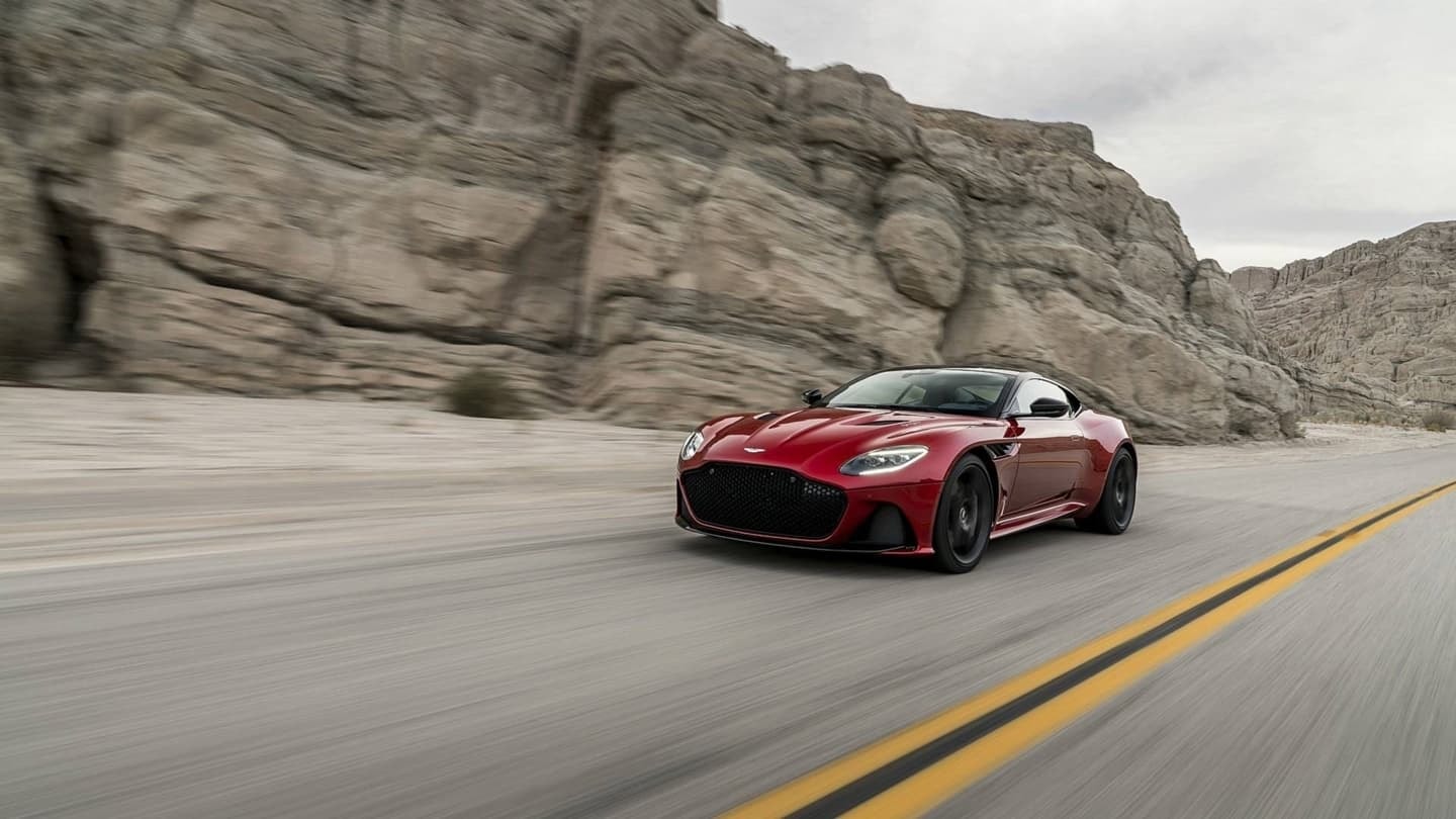 Vista lateral del Aston Martin DBS Superleggera acelerando en carretera abierta.