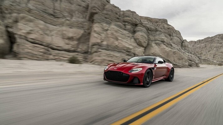 Vista lateral del Aston Martin DBS Superleggera acelerando en carretera abierta. Vista lateral del Aston Martin DBS Superleggera acelerando en carretera abierta.