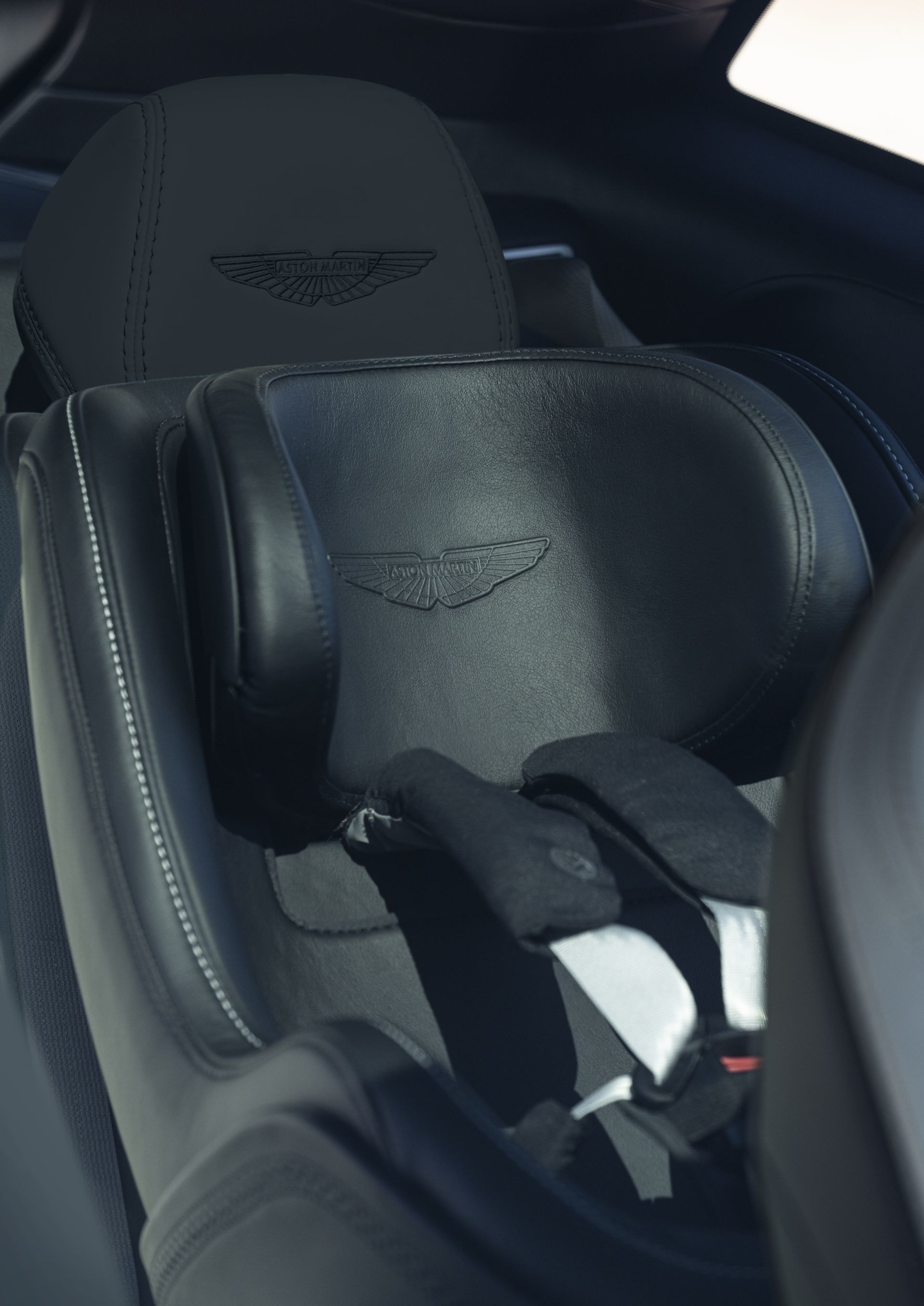 Asiento infantil de diseño deportivo con el emblema de Aston Martin.