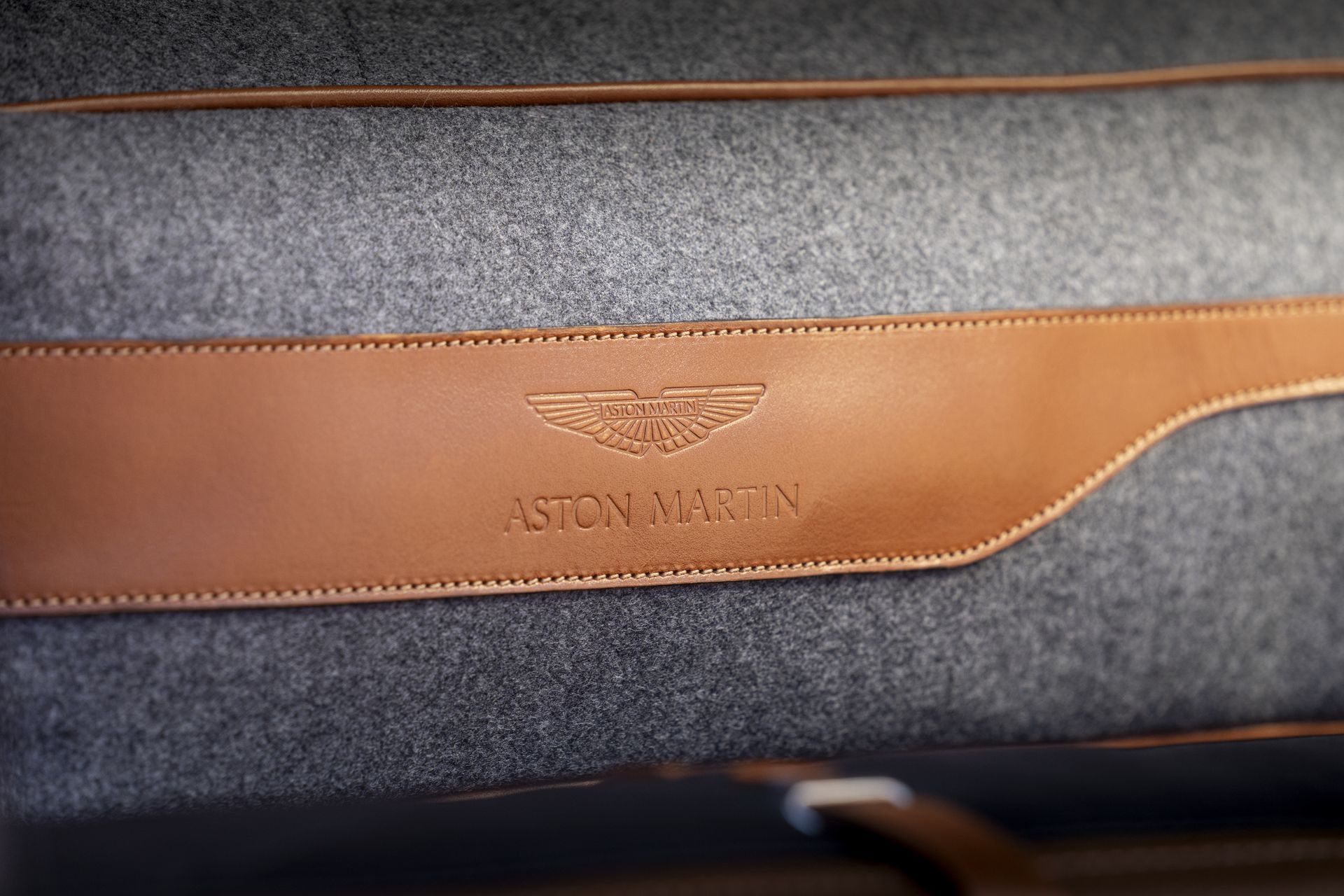 Elegante costura con el emblema de Aston Martin, simboliza lujo en cada detalle.