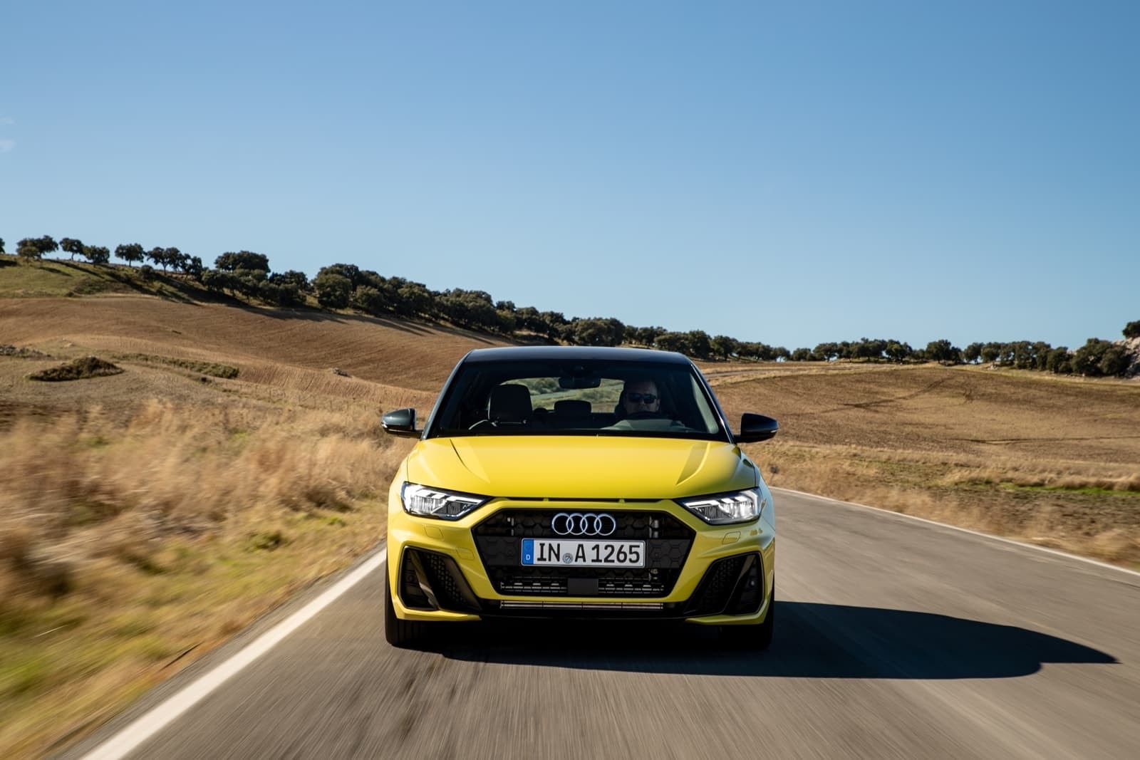 Perfil lateral del Audi A1 en carretera, énfasis en su diseño deportivo.