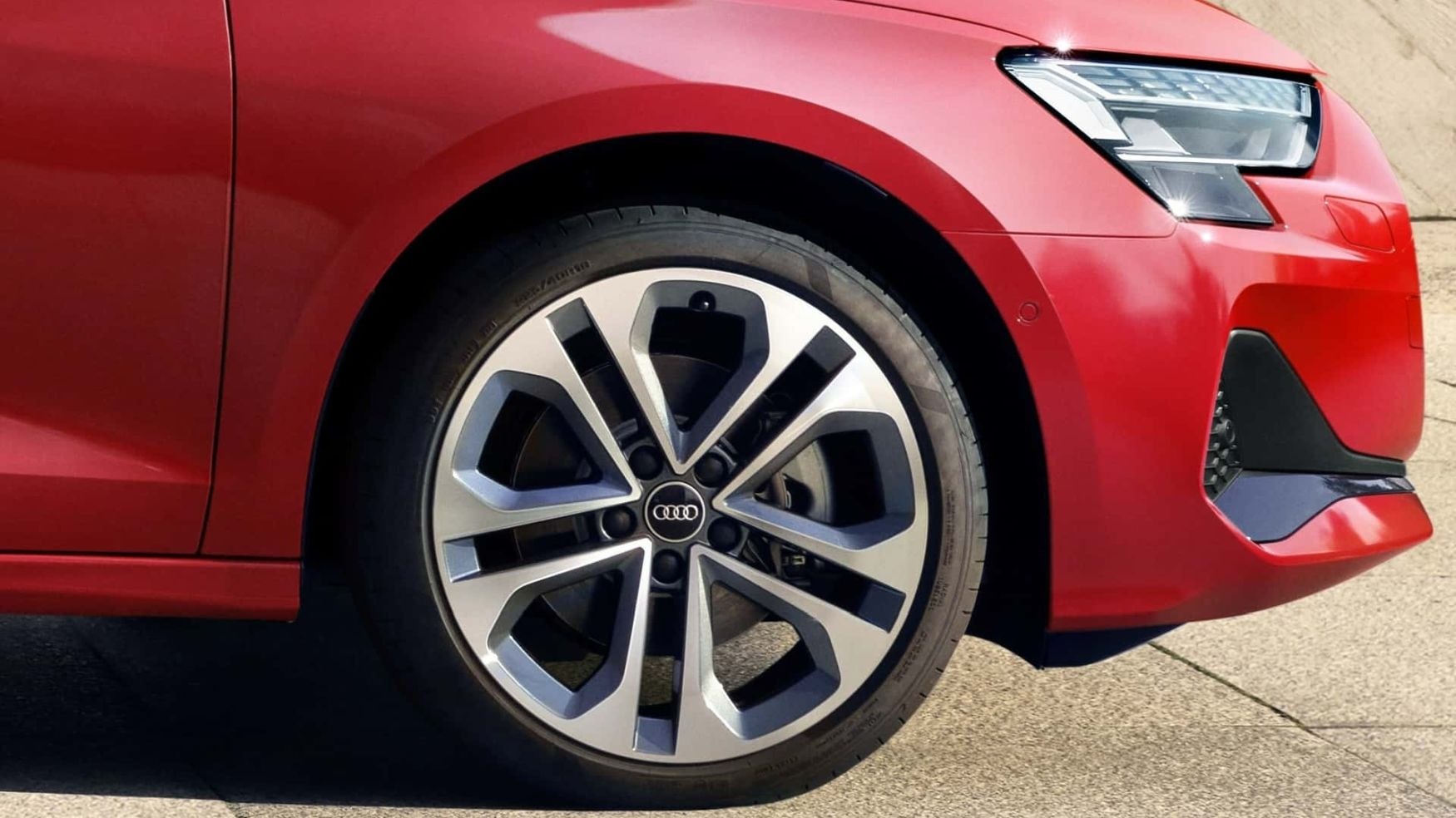 Audi A3 Sedán rojo atravesando un puente, enfatizando su dinámica y atleta.