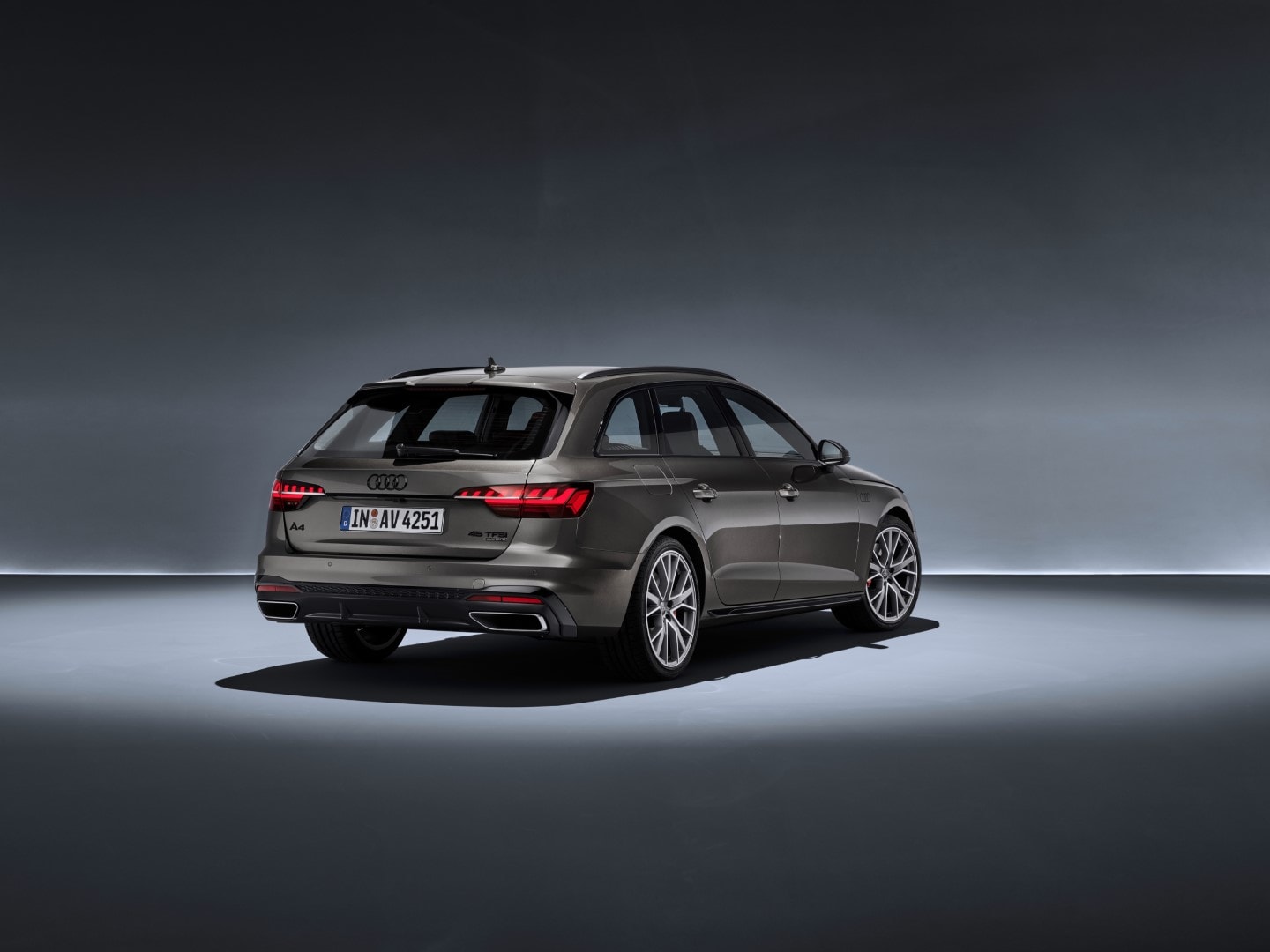 Perspectiva trasera y lateral del Audi A4 Avant bajo iluminación de estudio.