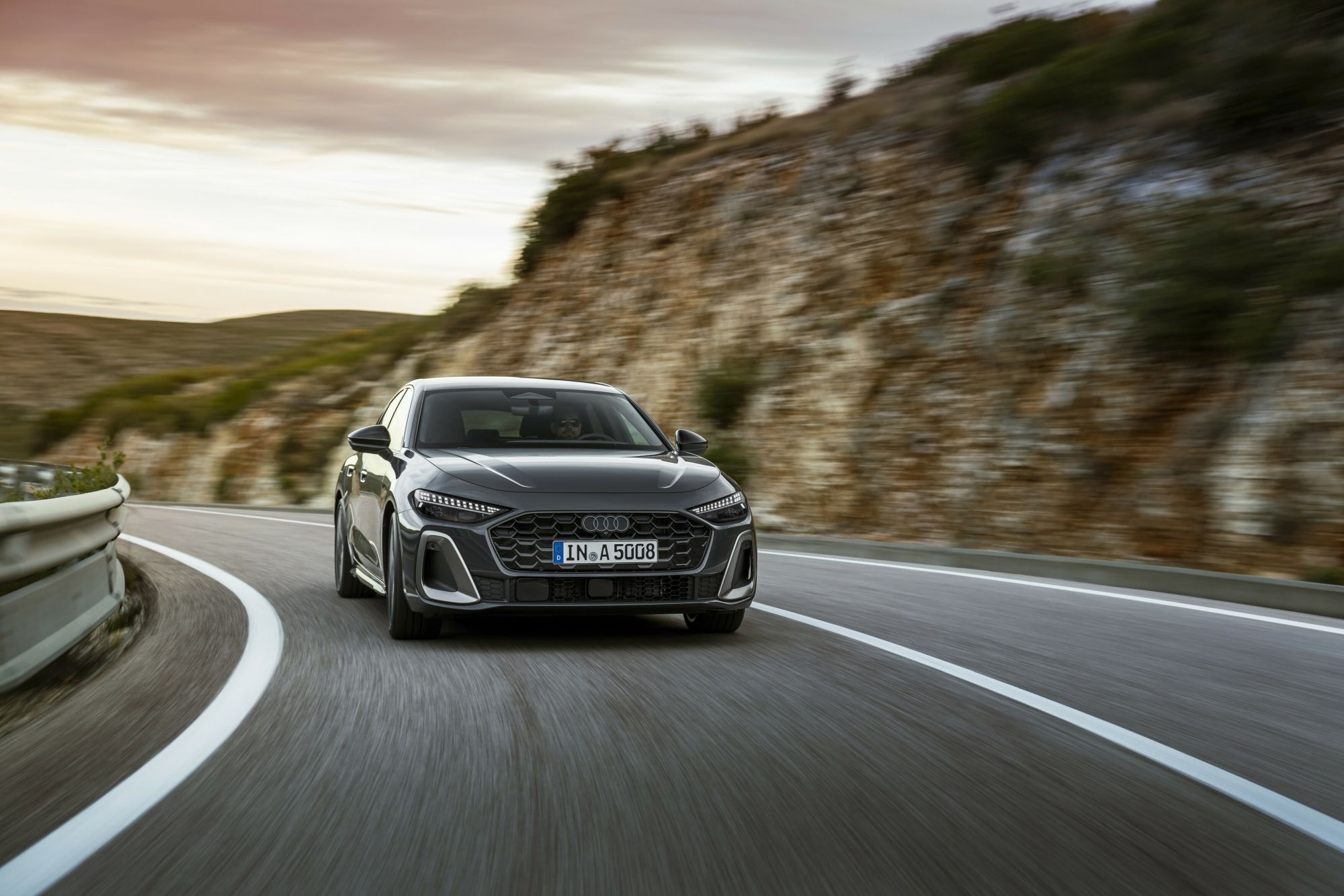 Vista trasera del Audi A5 en una curva, resaltando su diseño elegante.