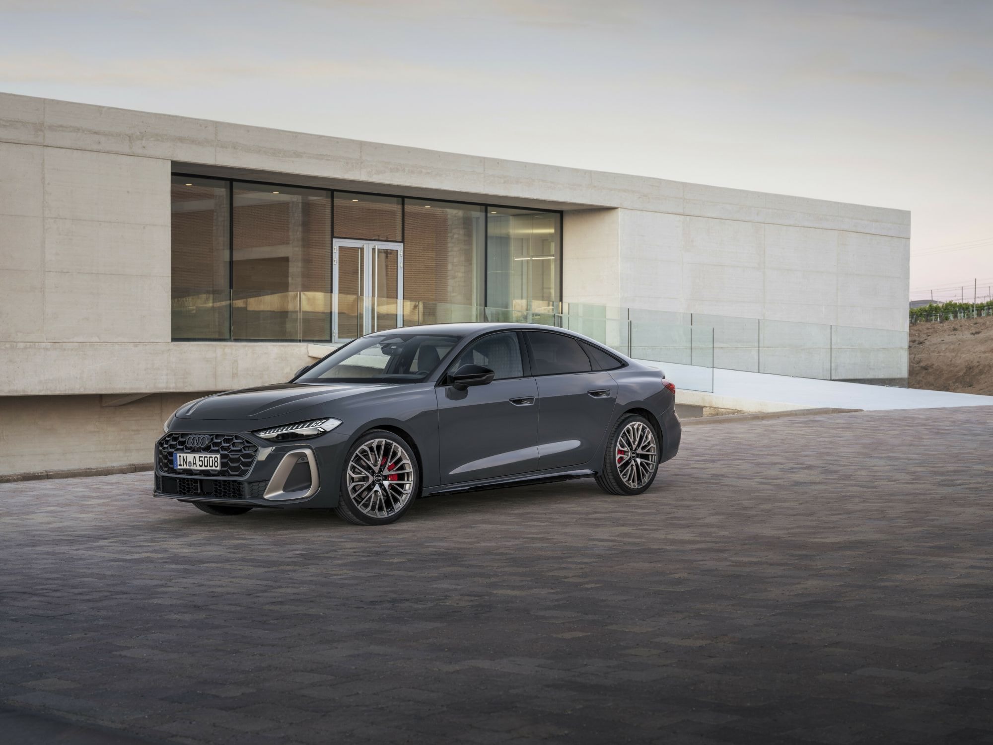 Audi A5 en movimiento, capturando su estampa deportiva en una carretera sinuosa.
