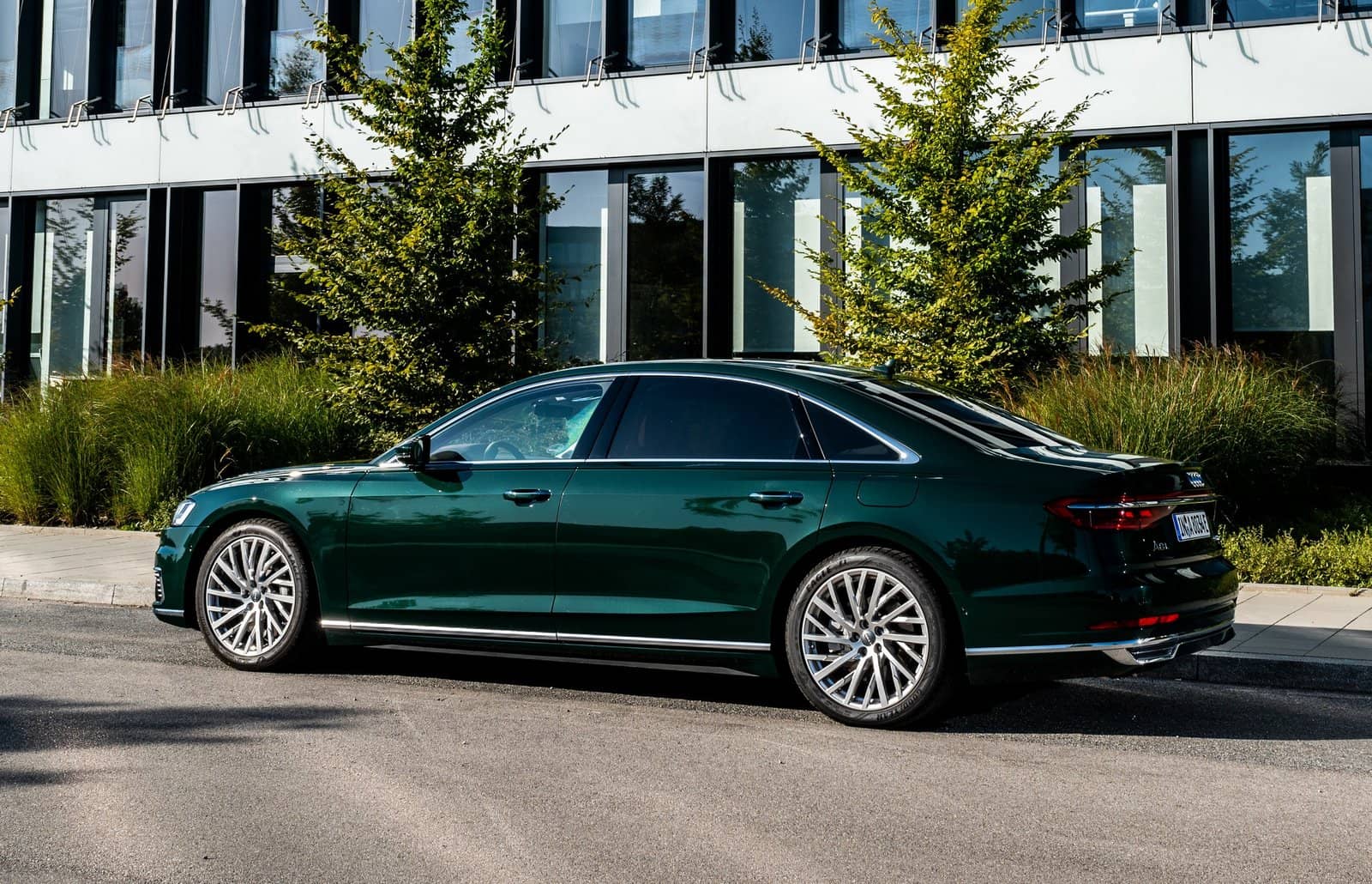 Perfil lateral del Audi A8 Híbrido estacionado, mostrando su línea y ruedas distintivas.