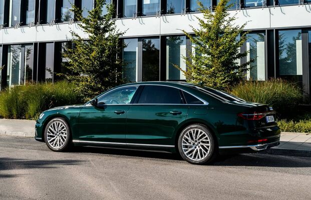 Perfil lateral del Audi A8 Híbrido estacionado, mostrando su línea y ruedas distintivas. Perfil lateral del Audi A8 Híbrido estacionado, mostrando su línea y ruedas distintivas.