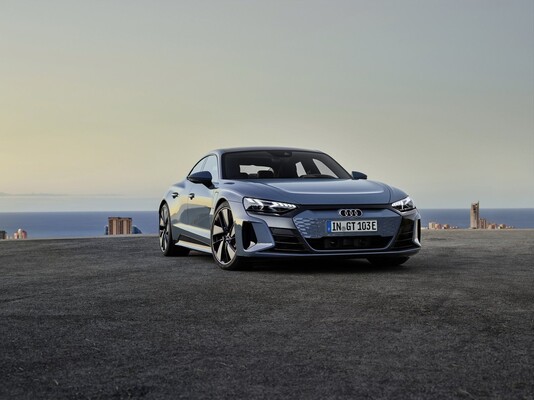 Vista frontal y lateral del Audi e-tron GT en un entorno costero.