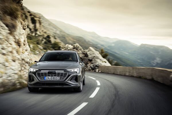 Imagen en acción del Audi Q8 e-tron mostrando su frontal robusto y estilizado. Imagen en acción del Audi Q8 e-tron mostrando su frontal robusto y estilizado.