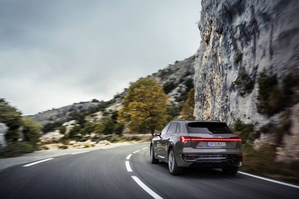 Vista dinámica de la trasera del Q8 e-tron en carretera, destacando sus líneas aerodinámicas. Vista dinámica de la trasera del Q8 e-tron en carretera, destacando sus líneas aerodinámicas.