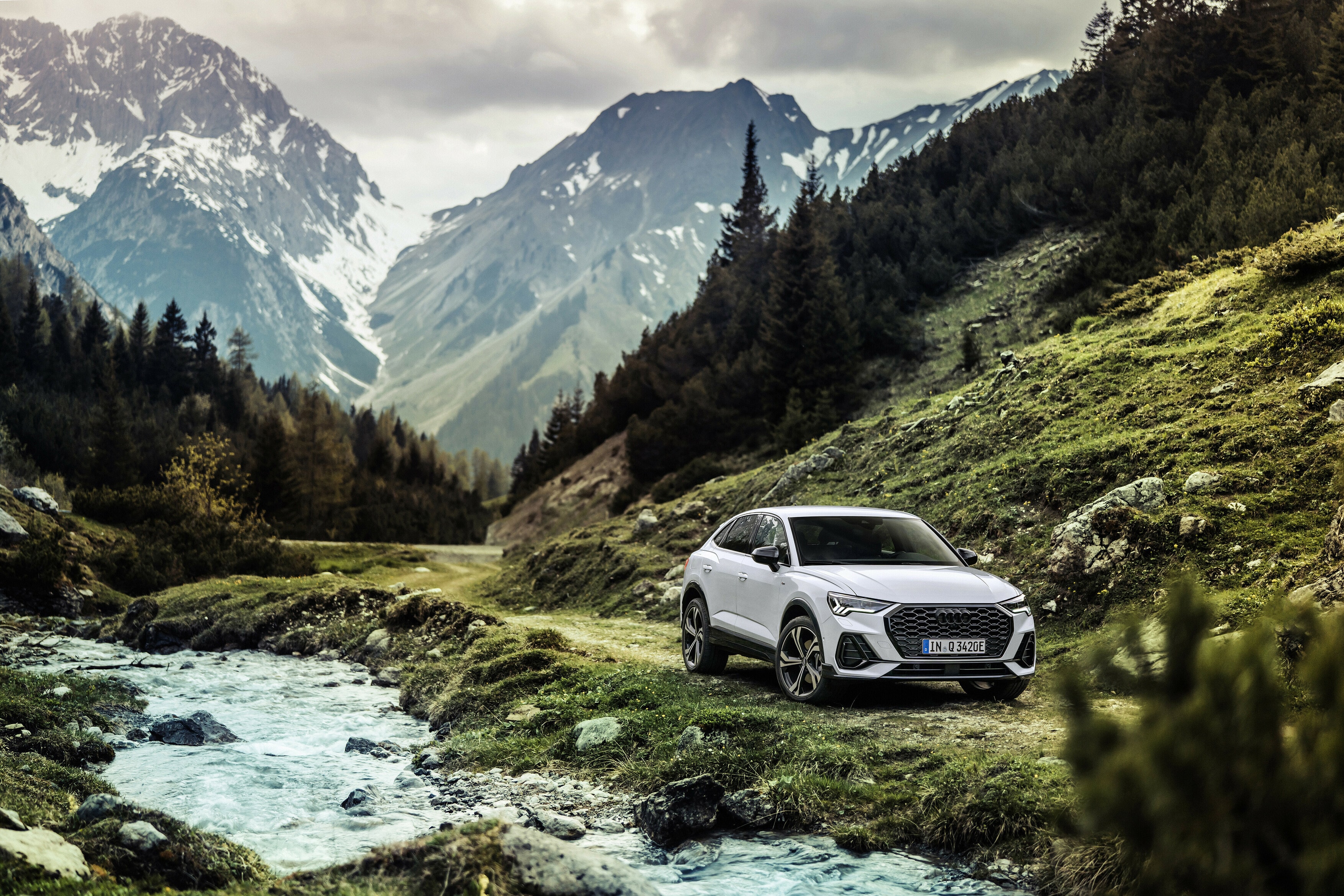 Vista posterior del Audi Q3 Sportback Híbrido en majestuoso paisaje montañoso.