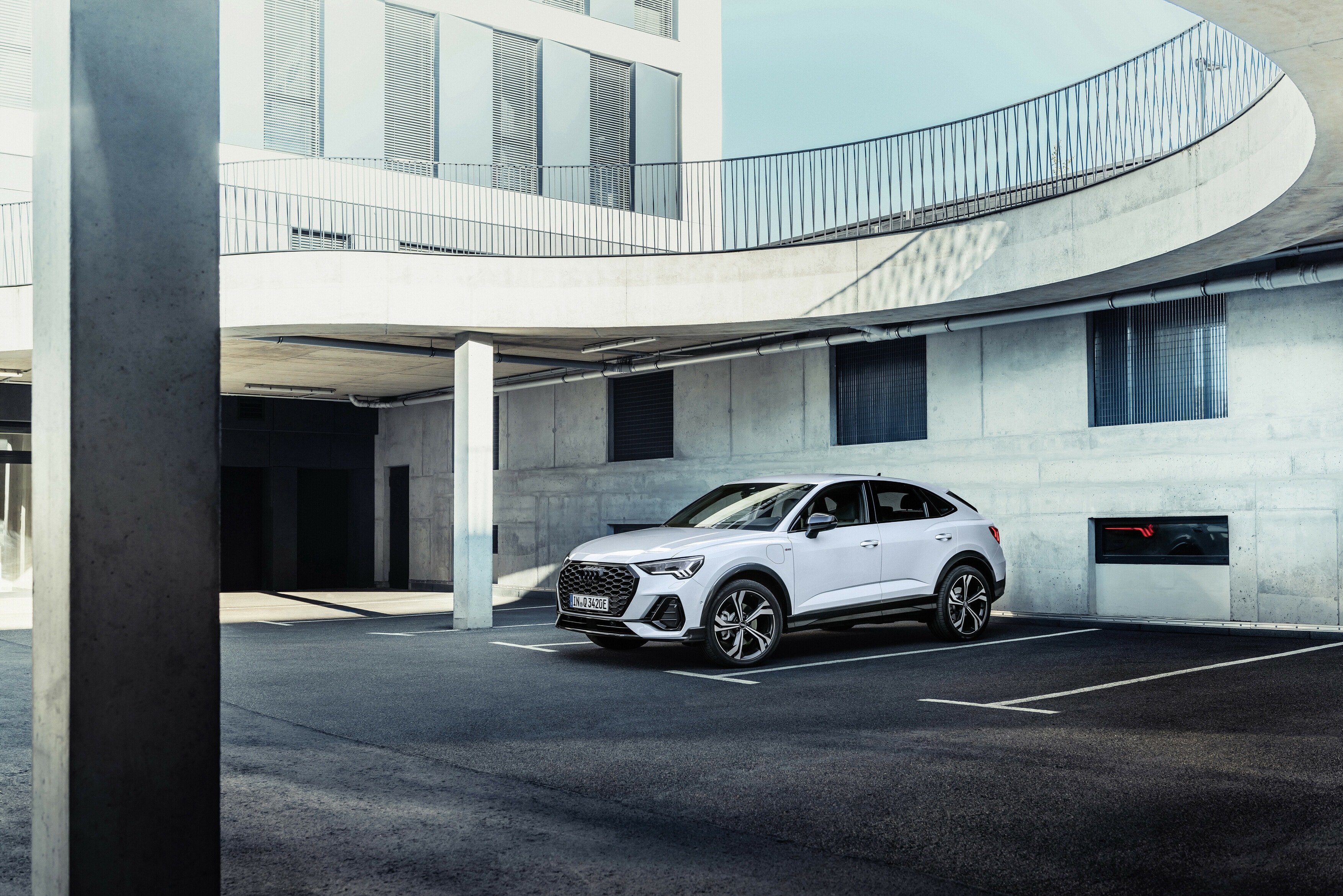 Audi Q3 Sportback aparcado frente a un edificio moderno, destacando su diseño lateral.