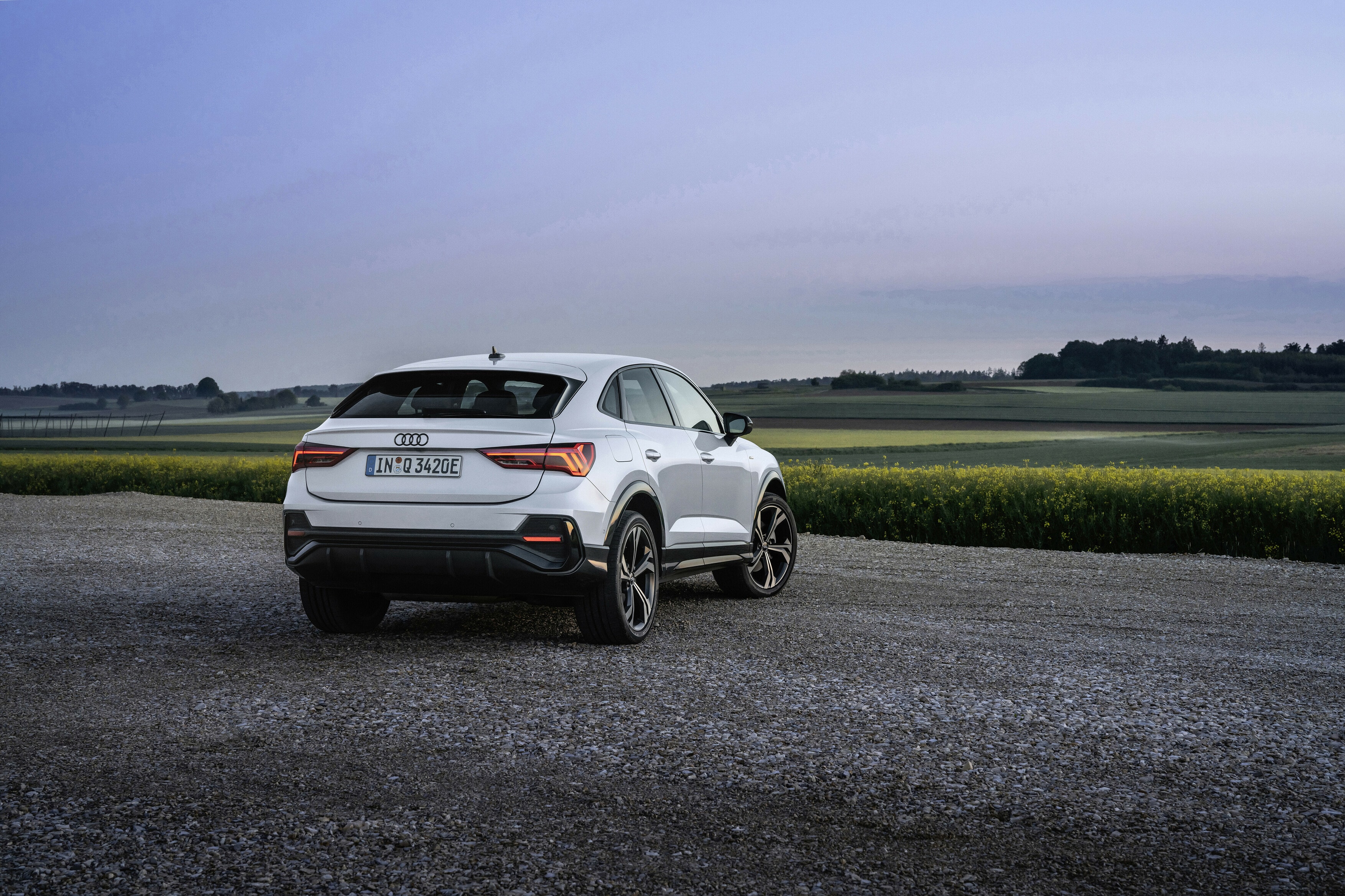 Imagen del Audi Q3 Sportback híbrido desde una perspectiva trasera y lateral al atardecer.