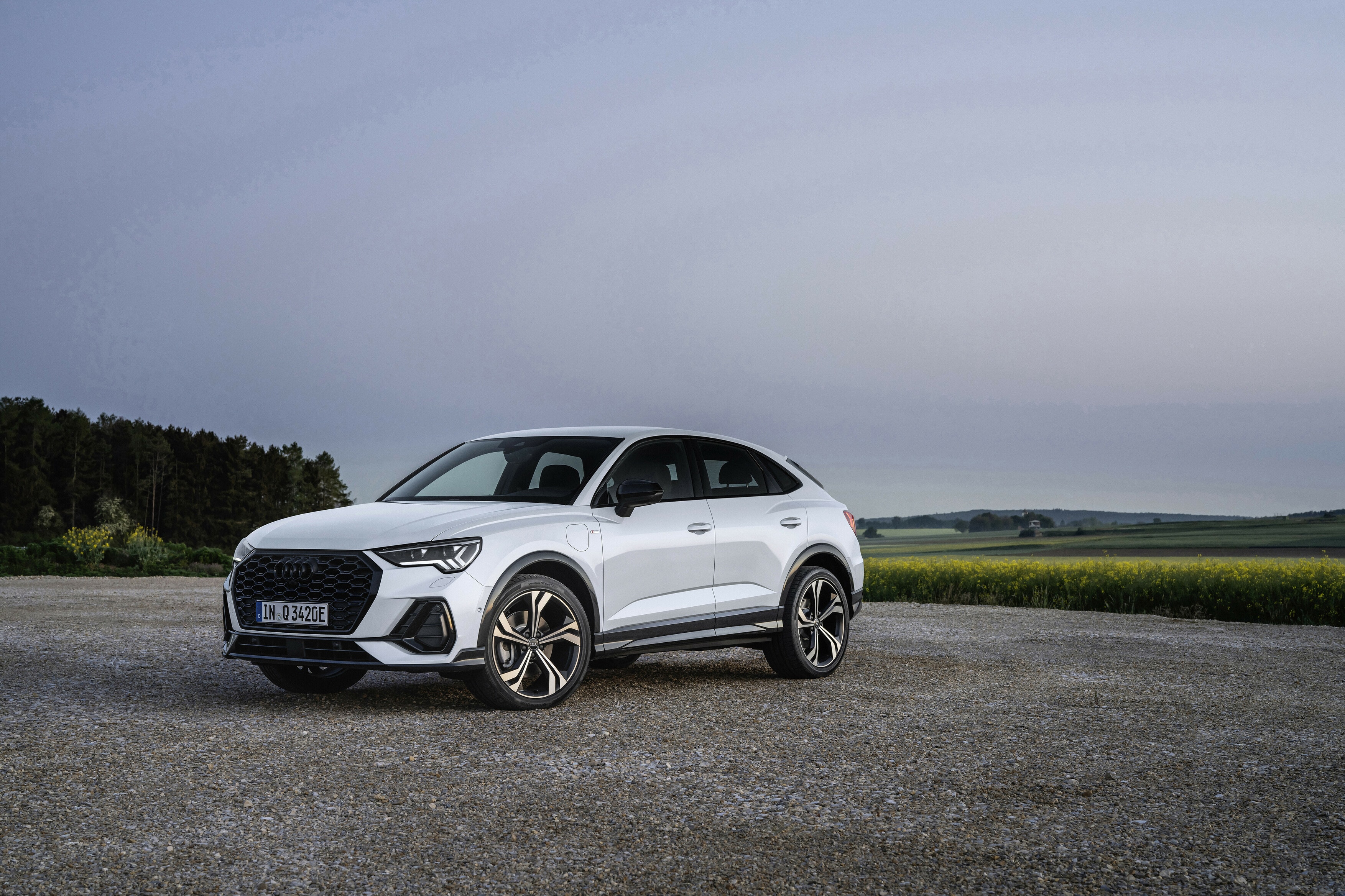 Vista frontal y lateral del Audi Q3 Sportback híbrido en un campo
