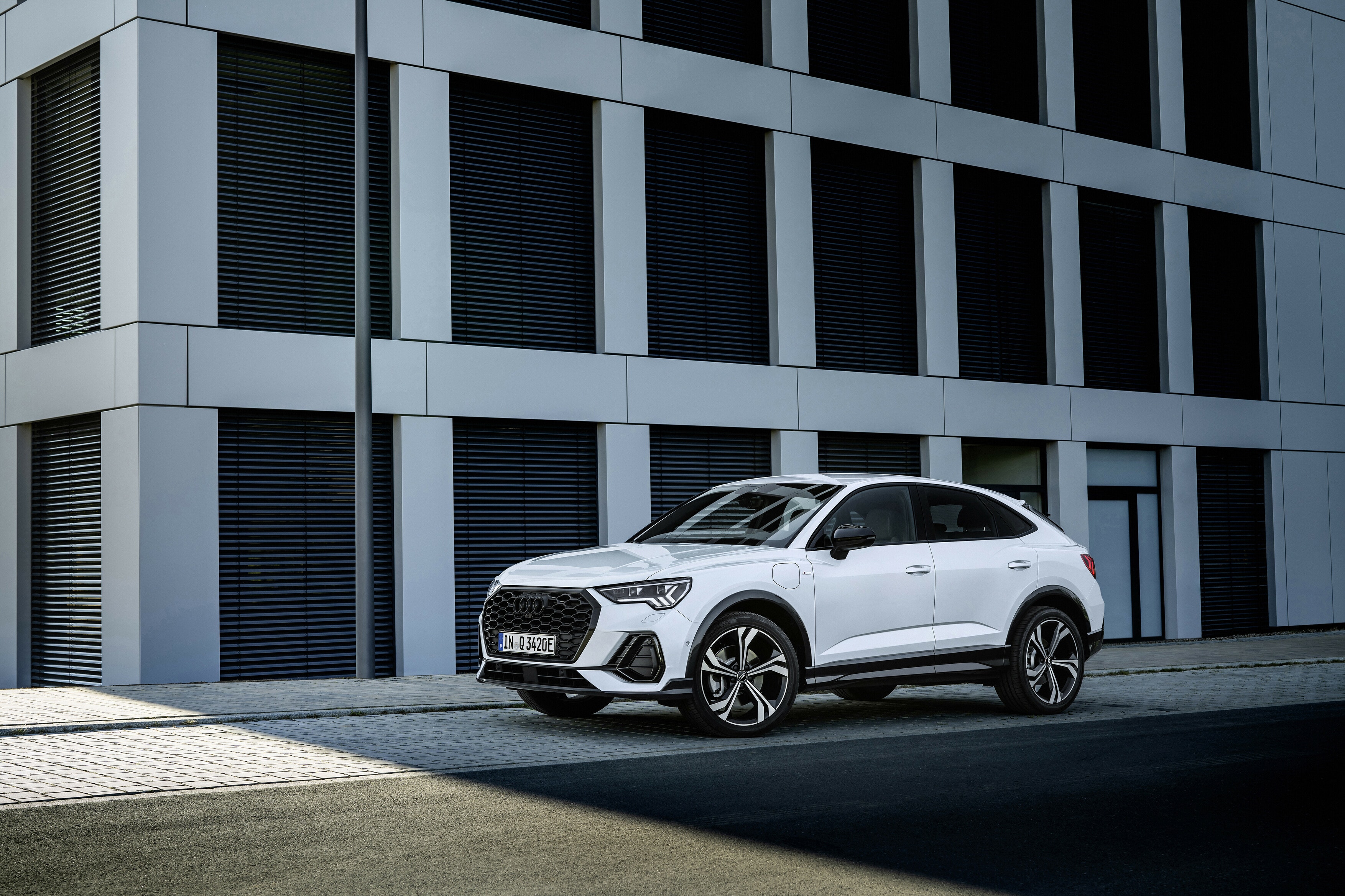 Perfil del Audi Q3 Sportback Híbrido resaltado por la arquitectura contemporánea.