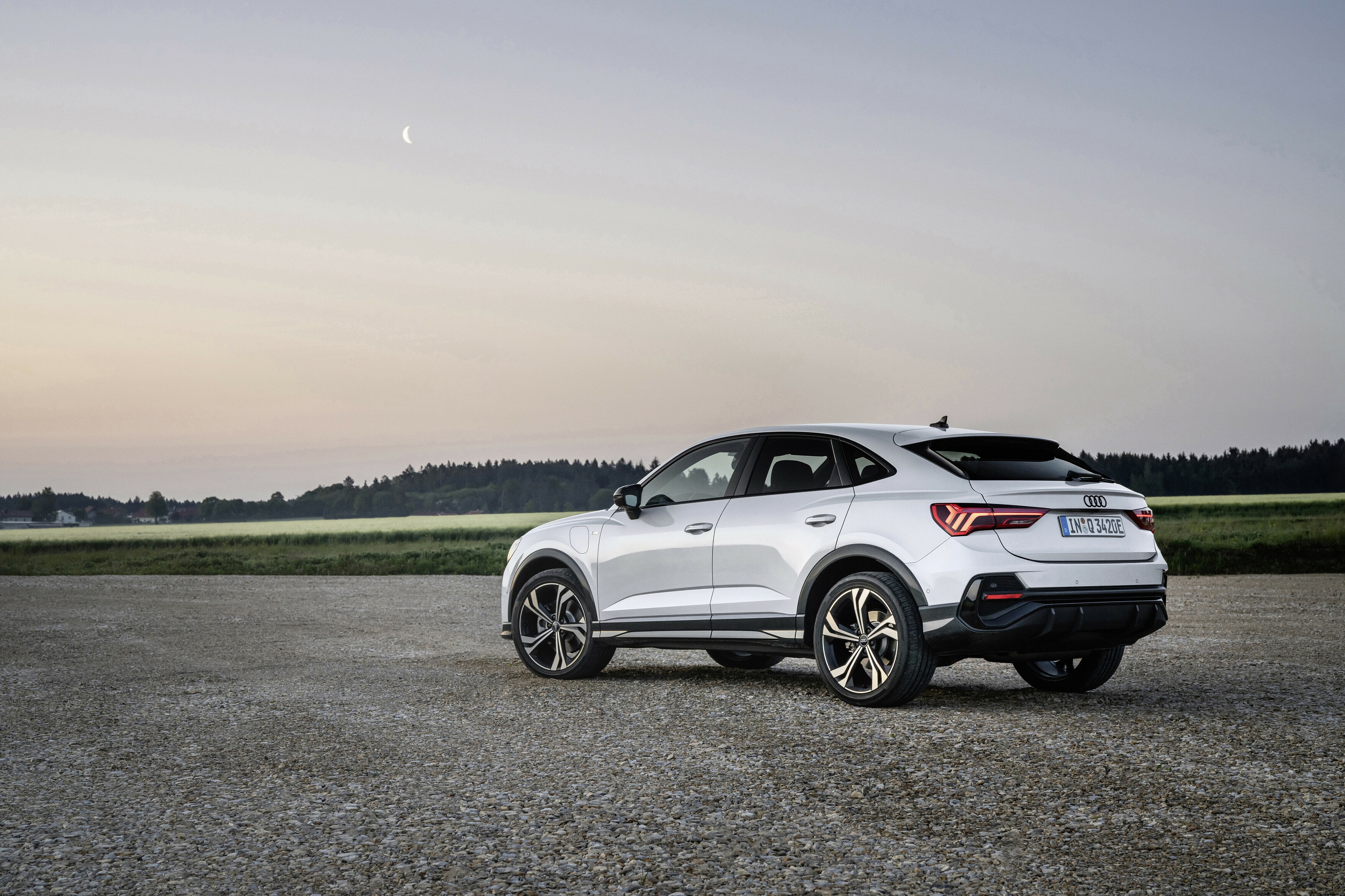 Vista trasera y lateral del Audi Q3 Sportback híbrido al atardecer