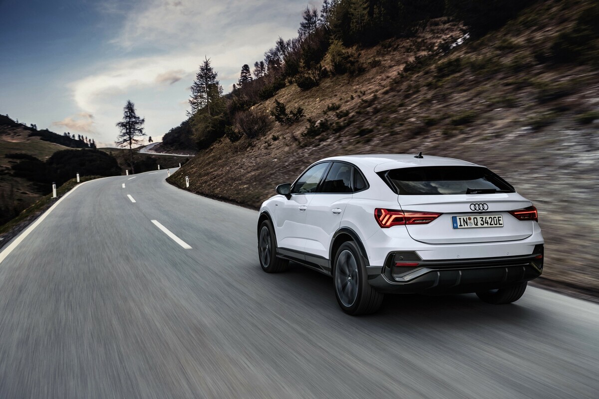 Trasera del Audi Q3 Sportback híbrido en carretera montañosa Trasera del Audi Q3 Sportback híbrido en carretera montañosa