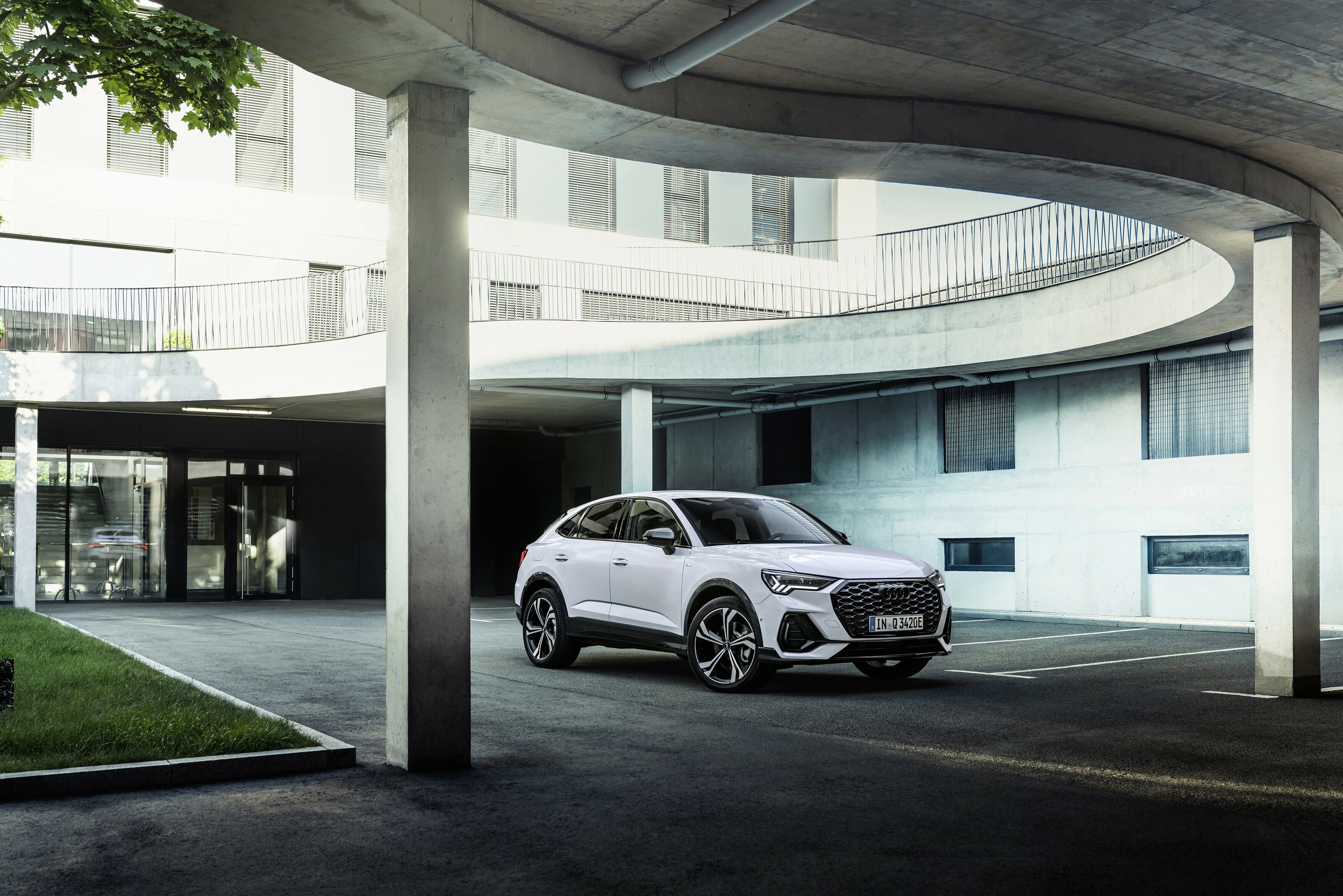 Audi Q3 Sportback Híbrido blanco bajo un sobrepaso, destacando su diseño moderno.