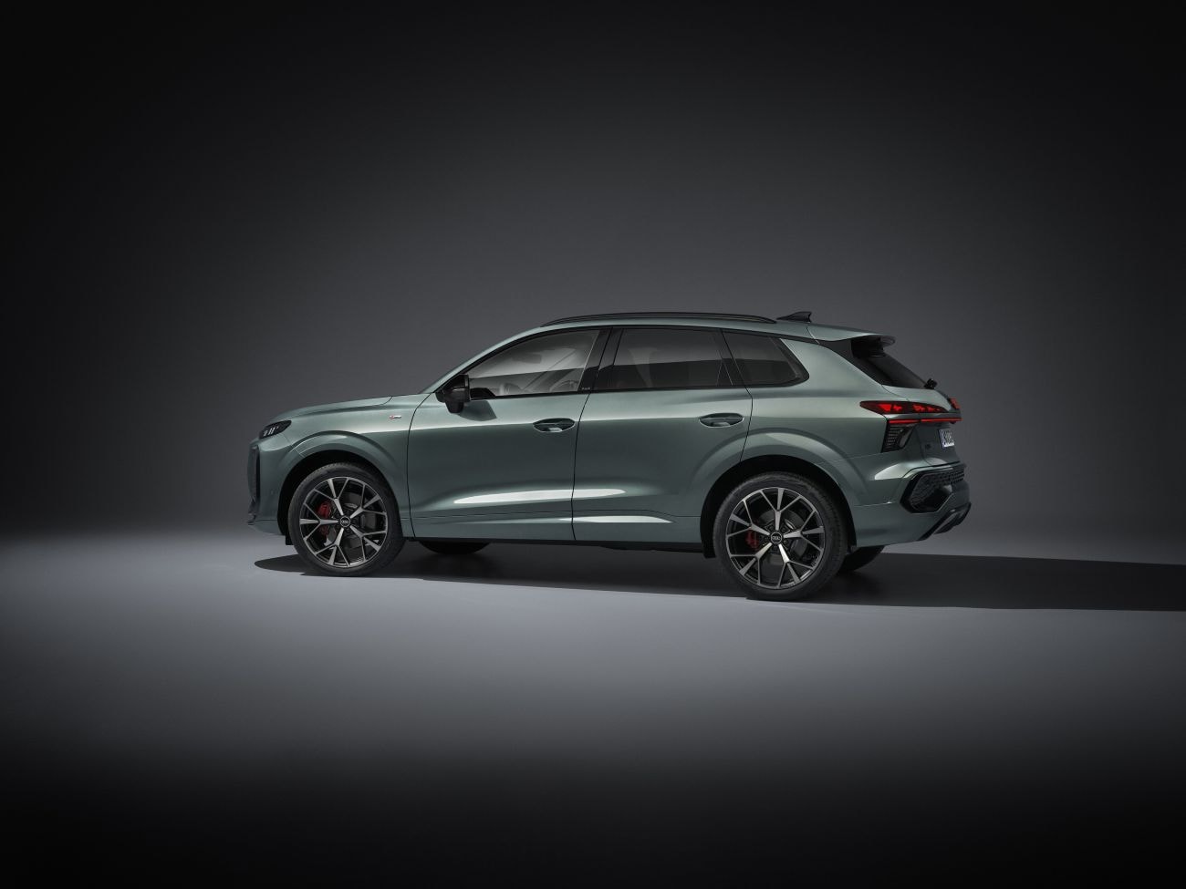 Frente del Audi Q3 en un paisaje residencial, mostrando su presencia imponente.