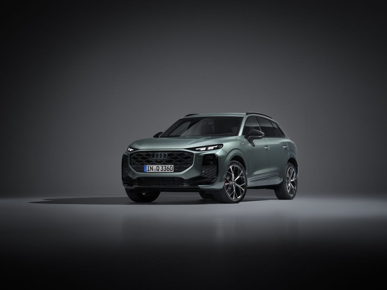 Perfil del Audi Q3 iluminado en estudio, resaltando sus líneas aerodinámicas.