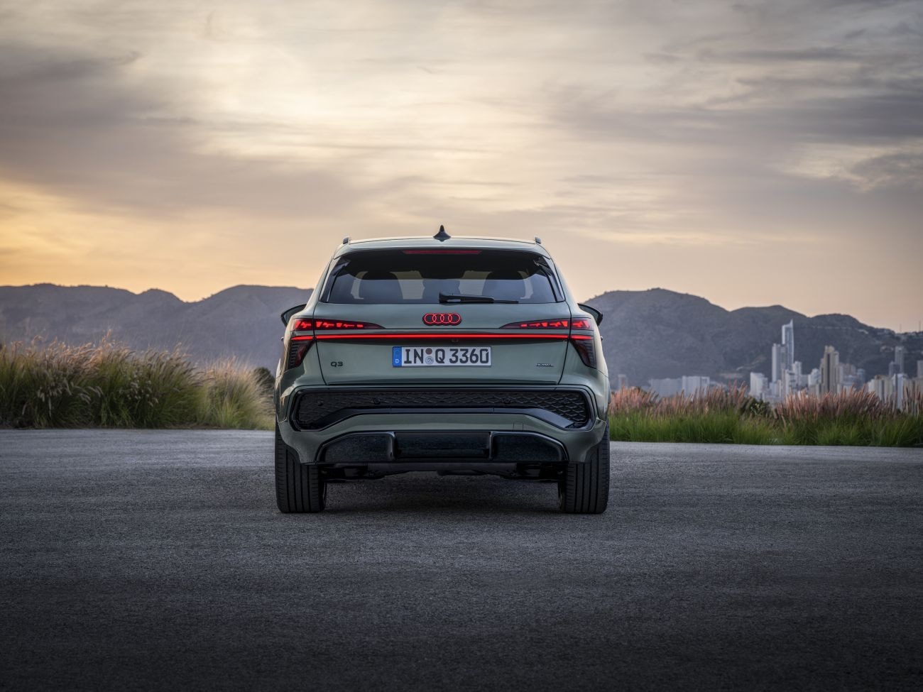 Perspectiva dinámica del Audi Q3 en un paisaje natural, resaltando su diseño.