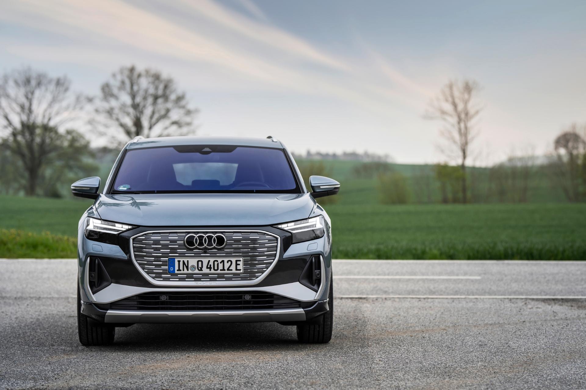 Vista frontal del Audi Q4 eléctrico con una puesta de sol nostálgica de fondo