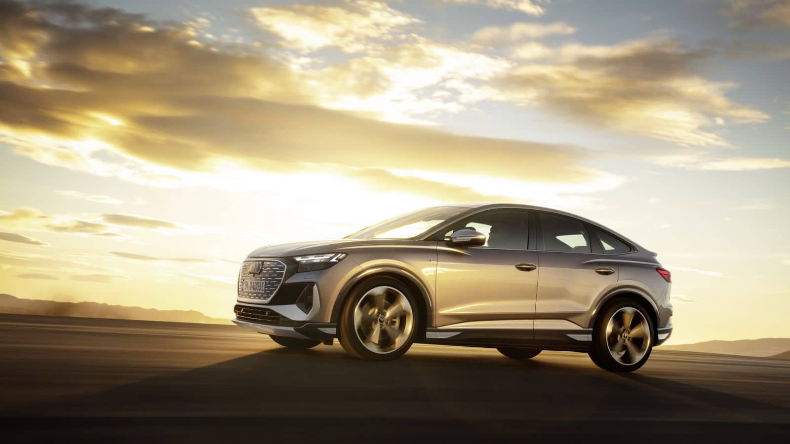 Silueta del Audi Q4 Sportback eléctrico contra un atardecer dorado.