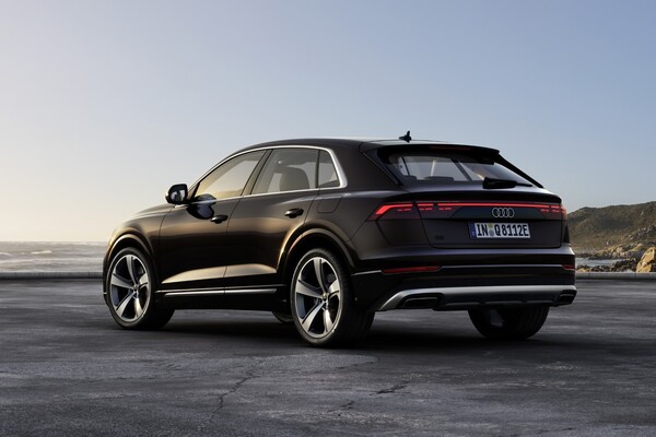 Perspectiva trasera y lateral del Audi Q8 híbrido destacando su diseño deportivo. Perspectiva trasera y lateral del Audi Q8 híbrido destacando su diseño deportivo.