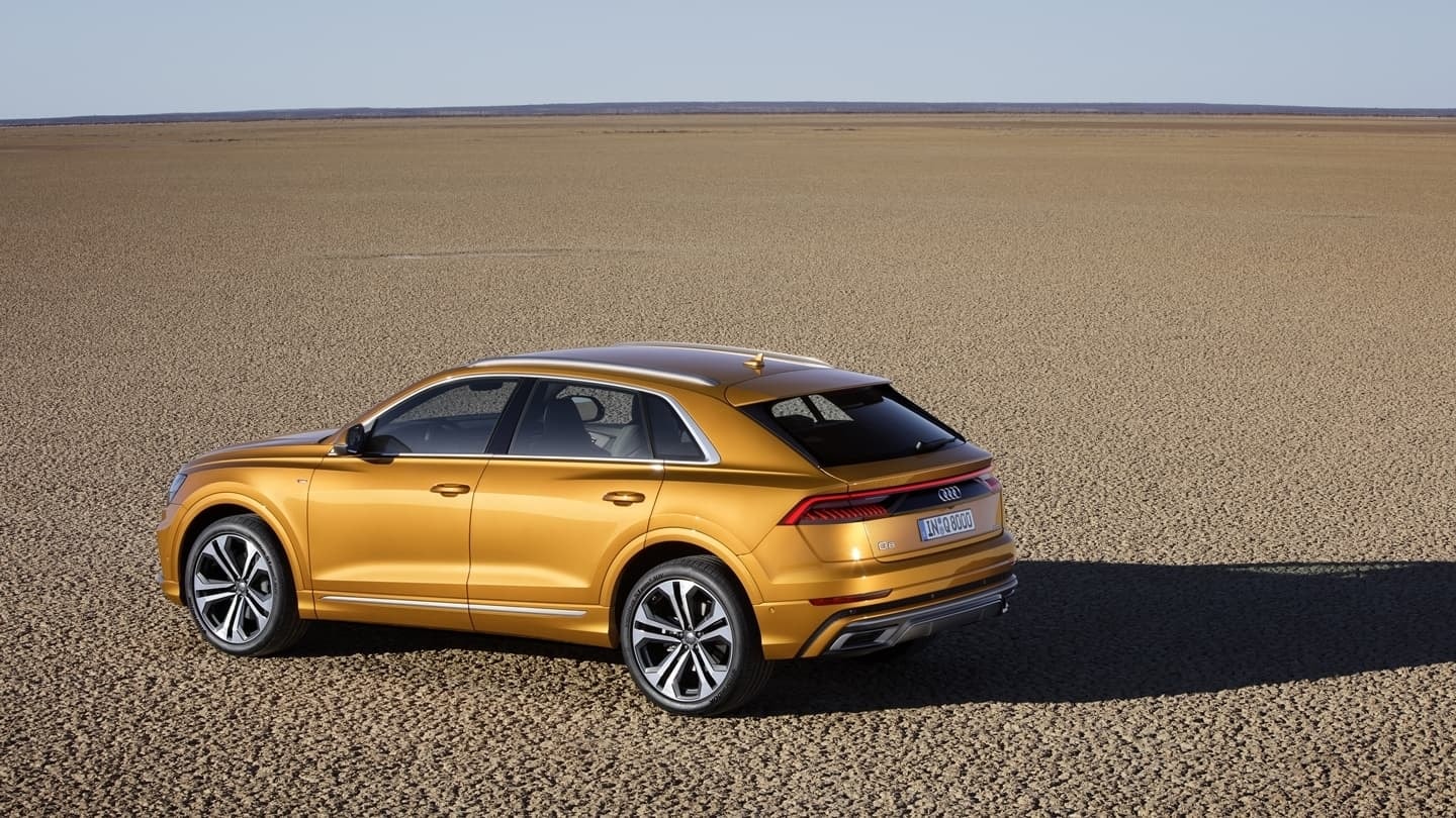 Perspectiva trasera y lateral del Audi Q8 revelando su potente presencia.
