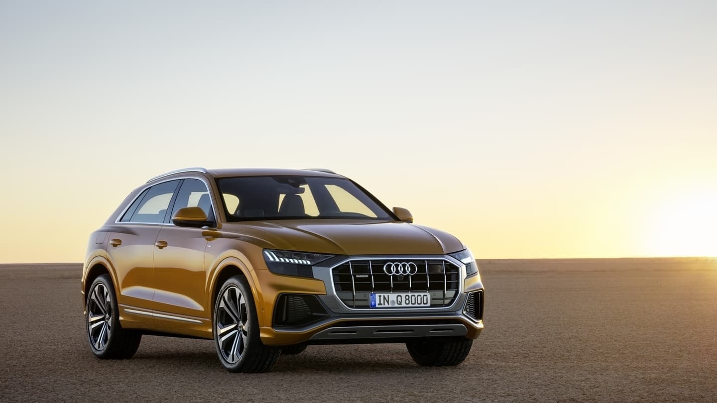 Frente imponente del Audi Q8 en un entorno de puesta de sol.