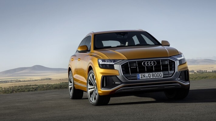 Vista frontal imponente del Audi Q8 con carrocería en color dorado.