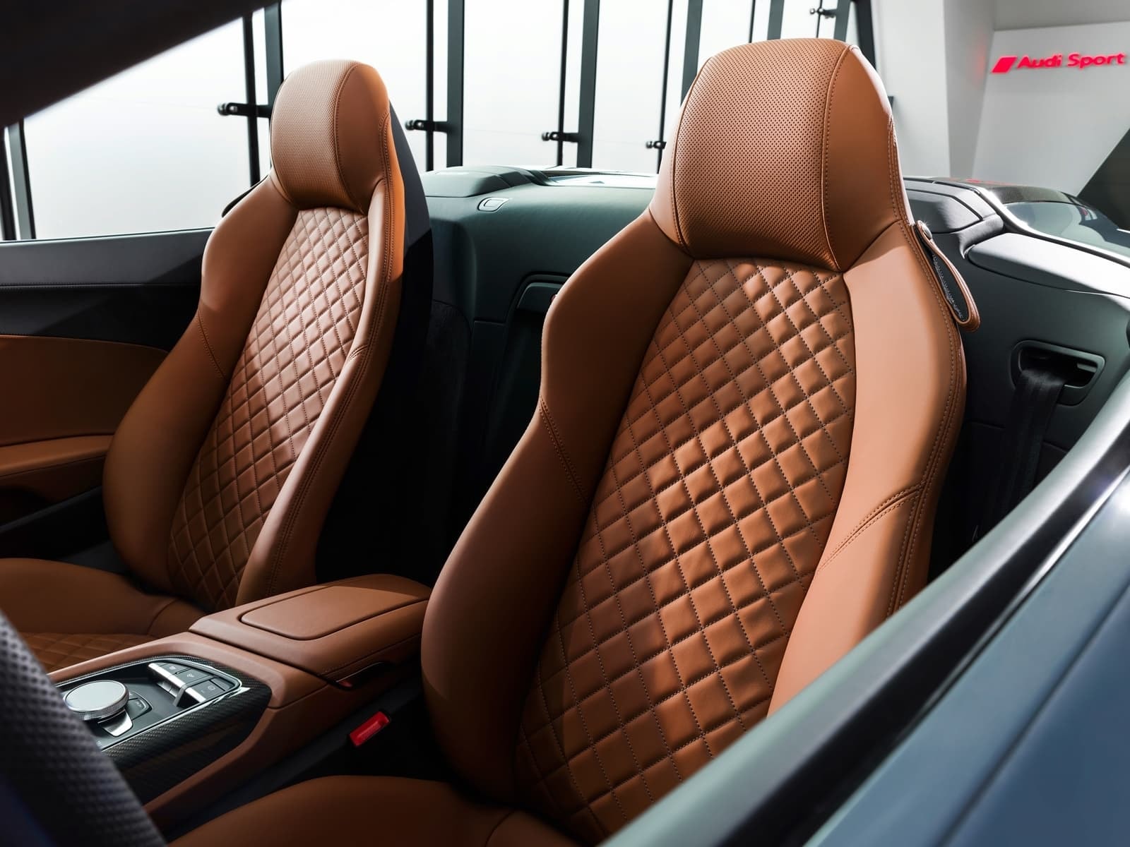 Detalle del diseño y acabados de los asientos y consola central del Audi R8.