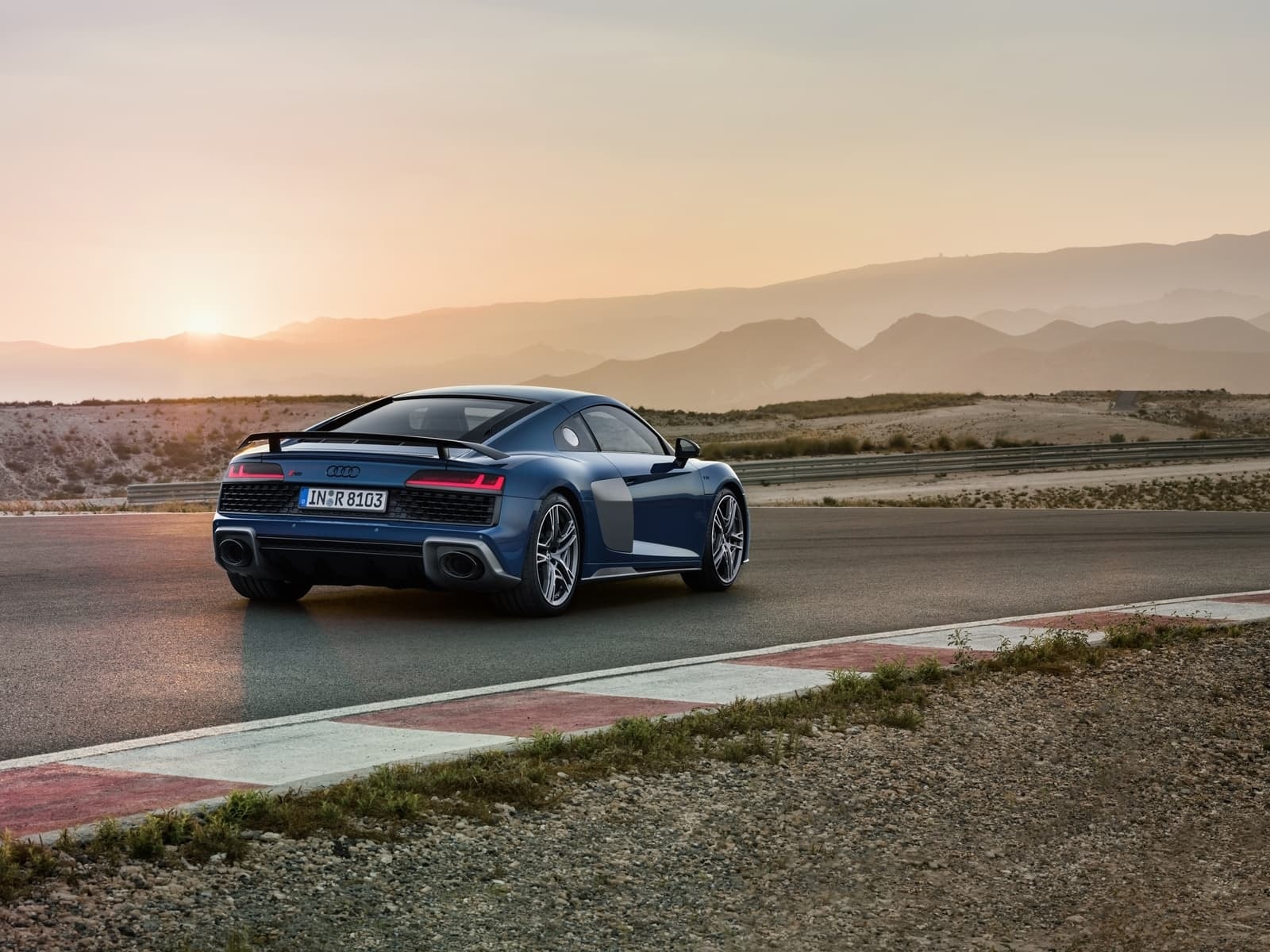 Audi R8 desde una vista lateral trasera con la luz del atardecer reflejando en su carrocería.