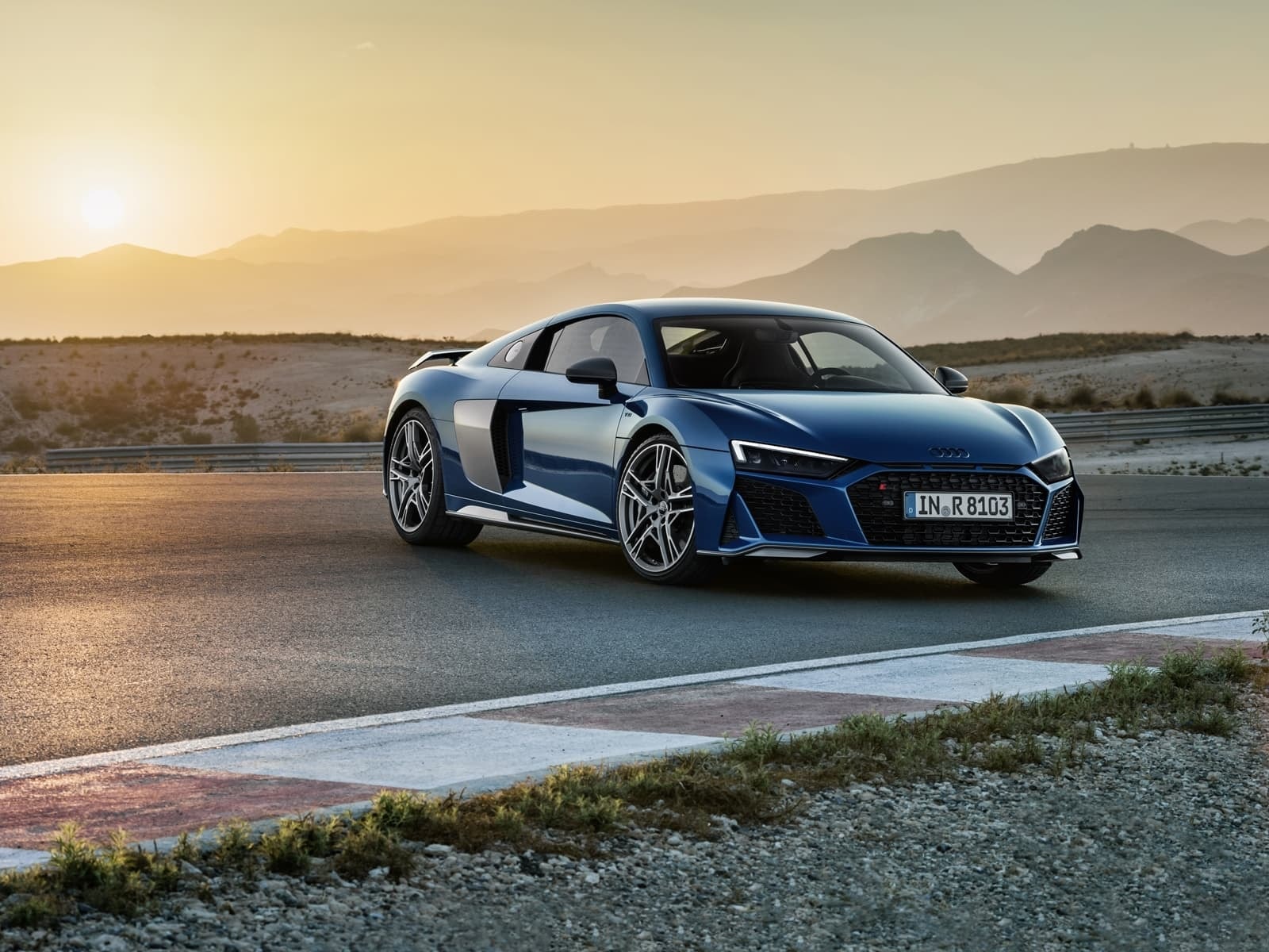 El Audi R8 delante mientras el sol se pone crea una imagen dramática y dinámica.