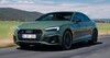 Vista frontal del Audi S5 en la carretera, destacando su imponente parrilla y faros agresivos. Vista frontal del Audi S5 en la carretera, destacando su imponente parrilla y faros agresivos.
