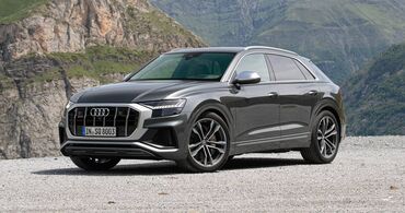 Audi SQ8 estacionado, destacando su robusta parrilla y faros LED. Audi SQ8 estacionado, destacando su robusta parrilla y faros LED.