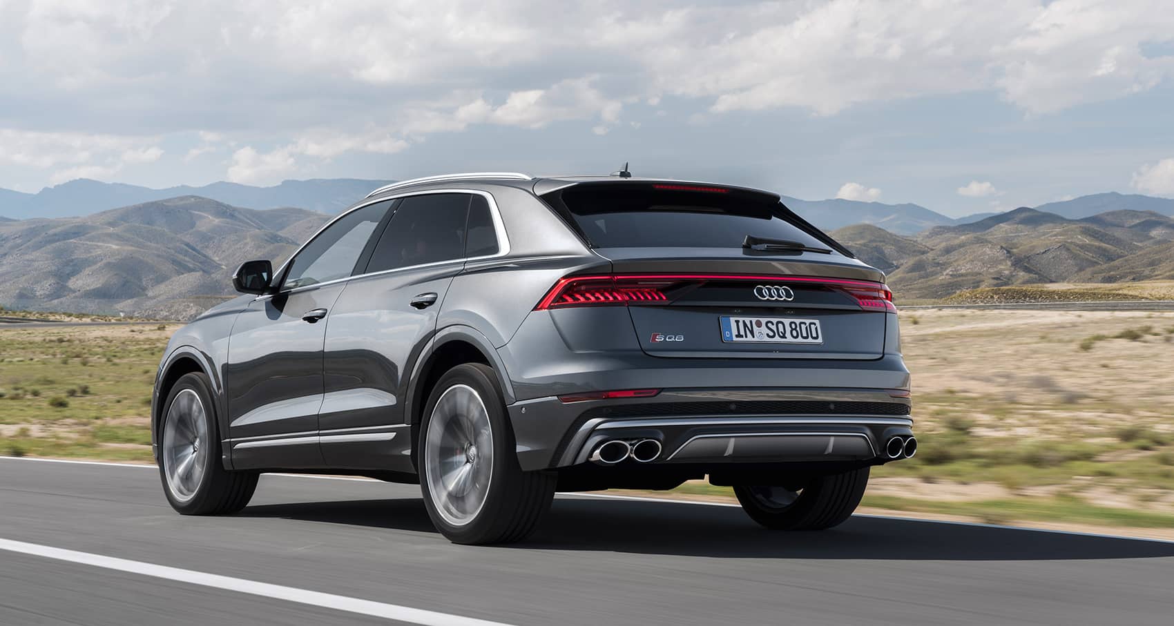 Imagen dinámica del Audi SQ8 mostrando su diseño trasero y líneas laterales.