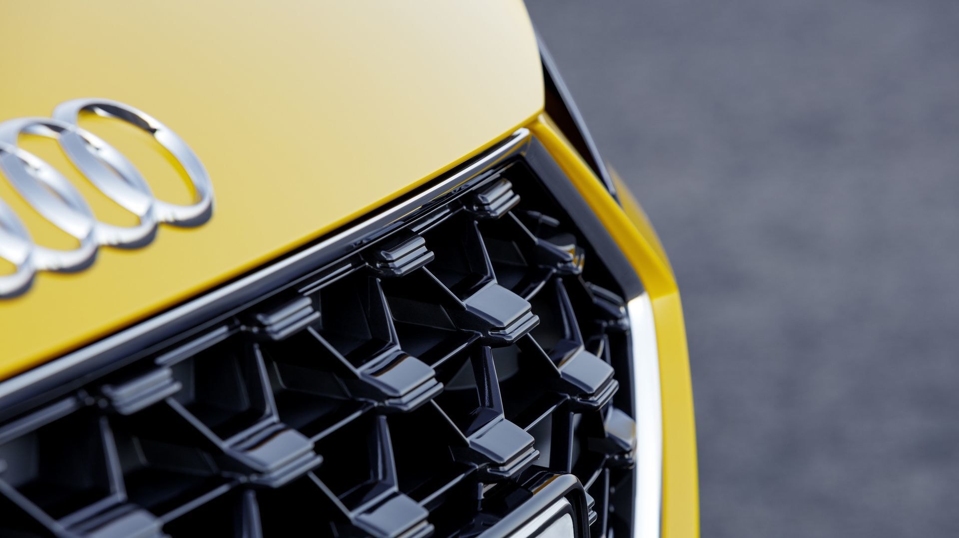 Primer plano de la icónica rejilla Audi con acabados cromados, símbolo de su linaje.