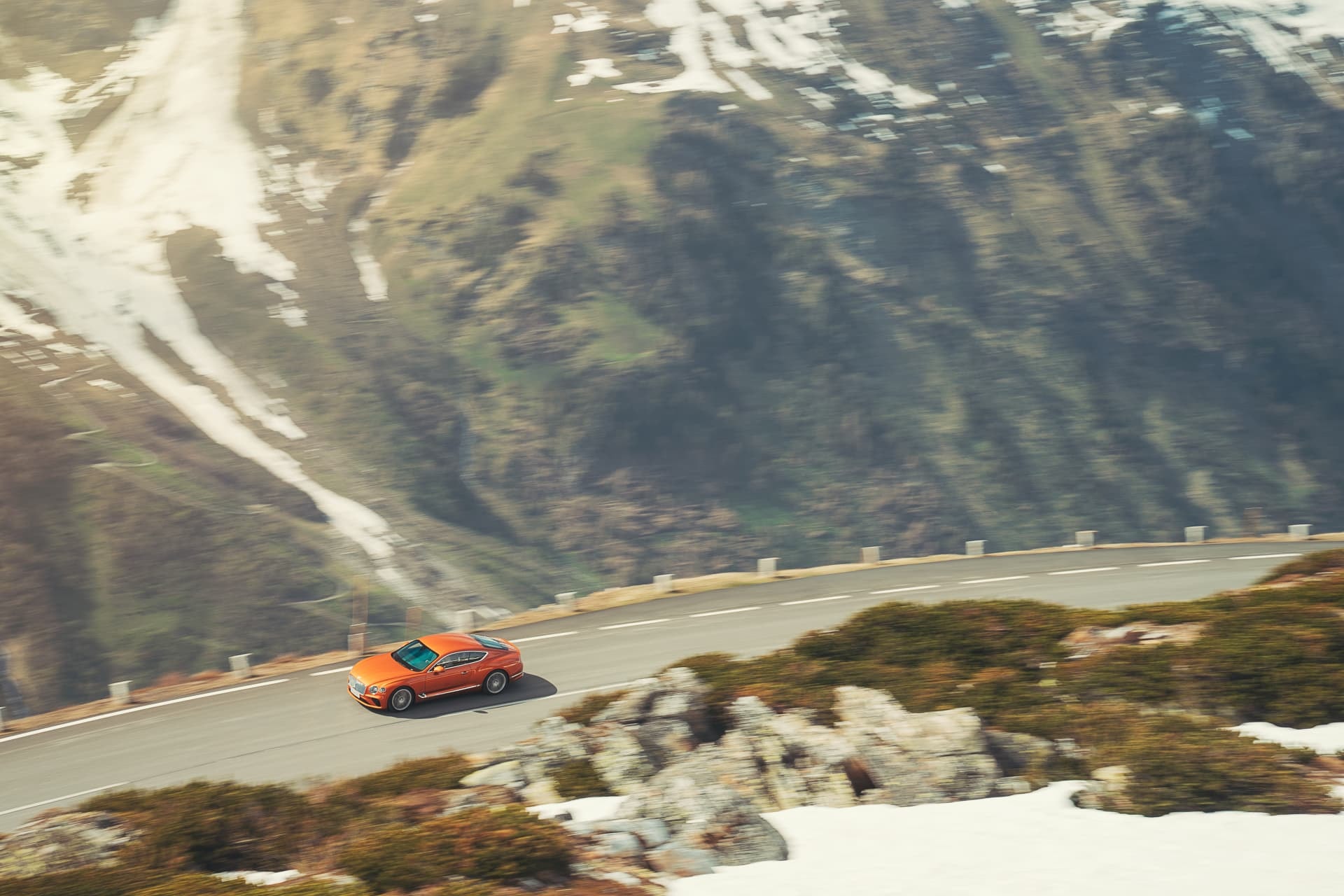 Bentley Continental GT en carretera de montaña, mostrando su línea lateral.
