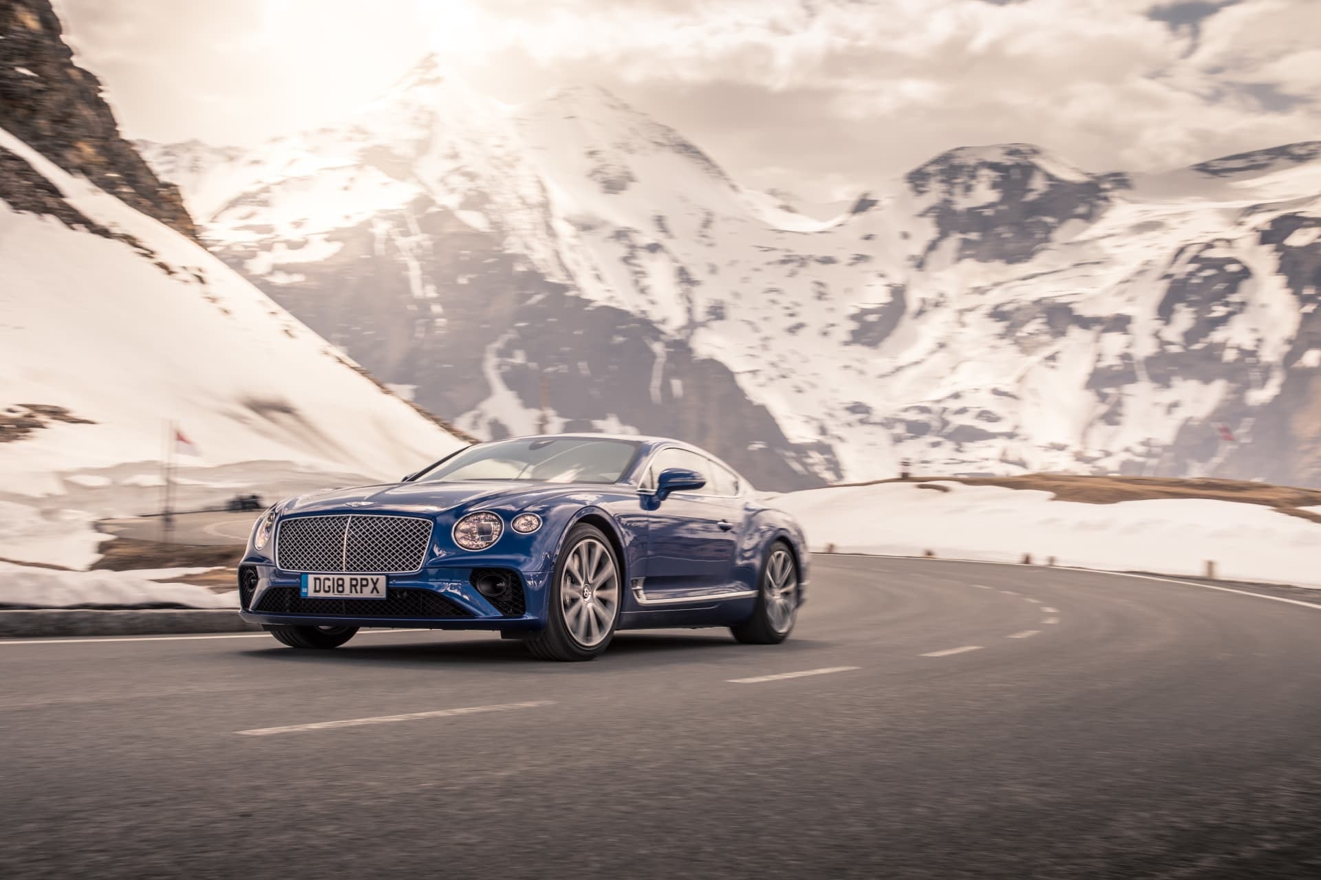 Control y elegancia del Bentley Continental GT tomando una curva de montaña.