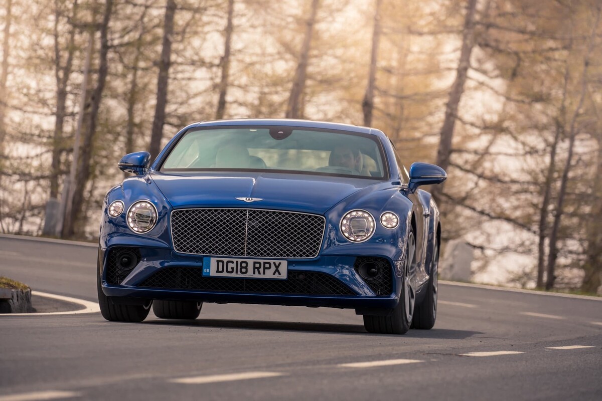 Bentley Continental GT azul afrontando curvas de montaña. Bentley Continental GT azul afrontando curvas de montaña.