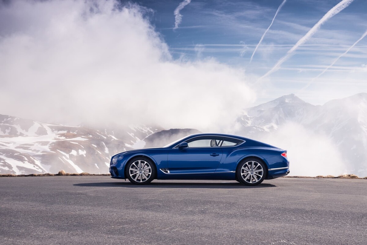 Vista lateral del Bentley Continental GT con montañas de fondo. Vista lateral del Bentley Continental GT con montañas de fondo.