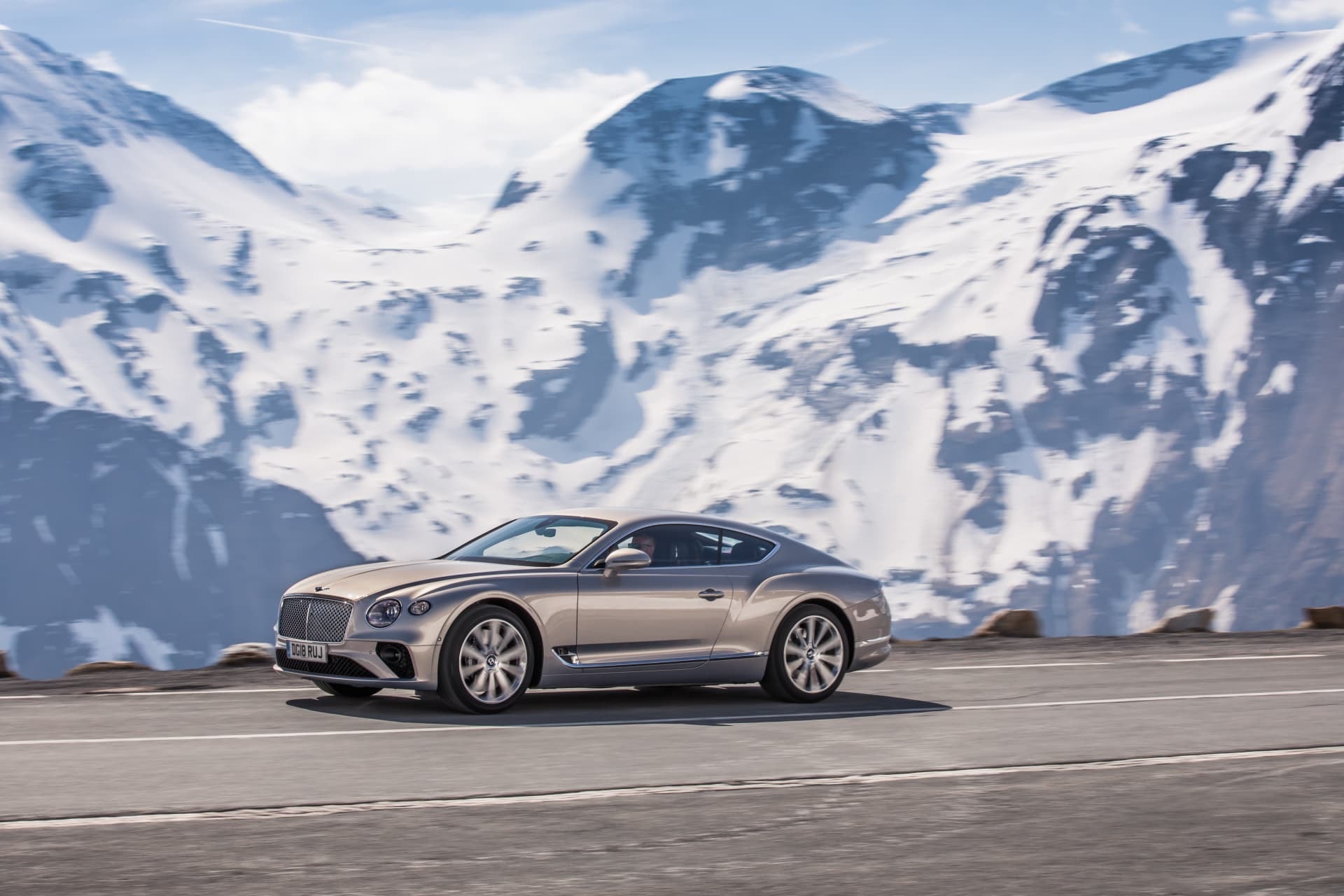 Bentley Continental GT en una toma lateral con un paisaje nevado de fondo.