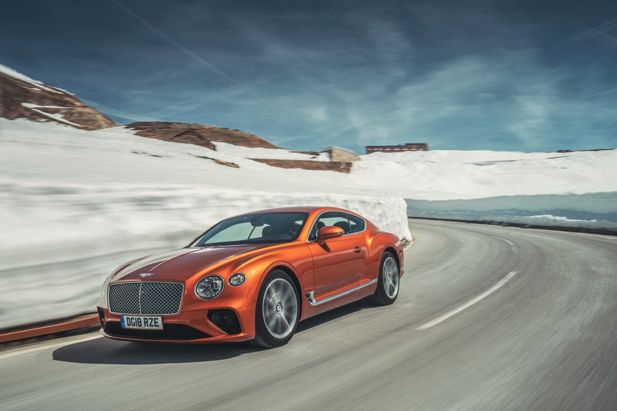 Vista dinámica del Bentley Continental GT, destacando su frontal y lateral en un entorno invernal. Vista dinámica del Bentley Continental GT, destacando su frontal y lateral en un entorno invernal.