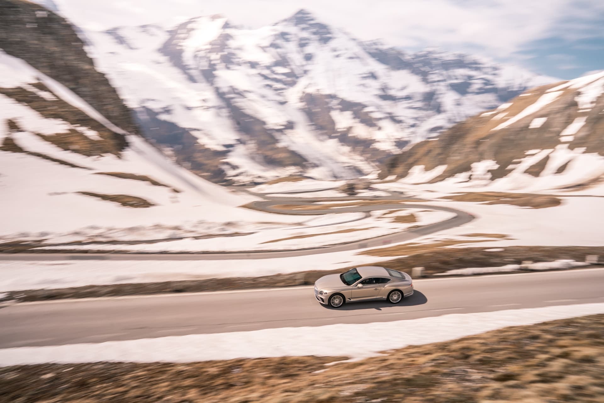 Perfil del Bentley Continental GT con un imponente paisaje alpino.